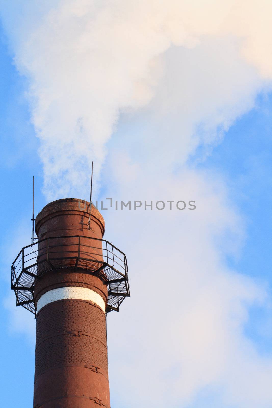 Closeup of smoking chimney on background with blue sky