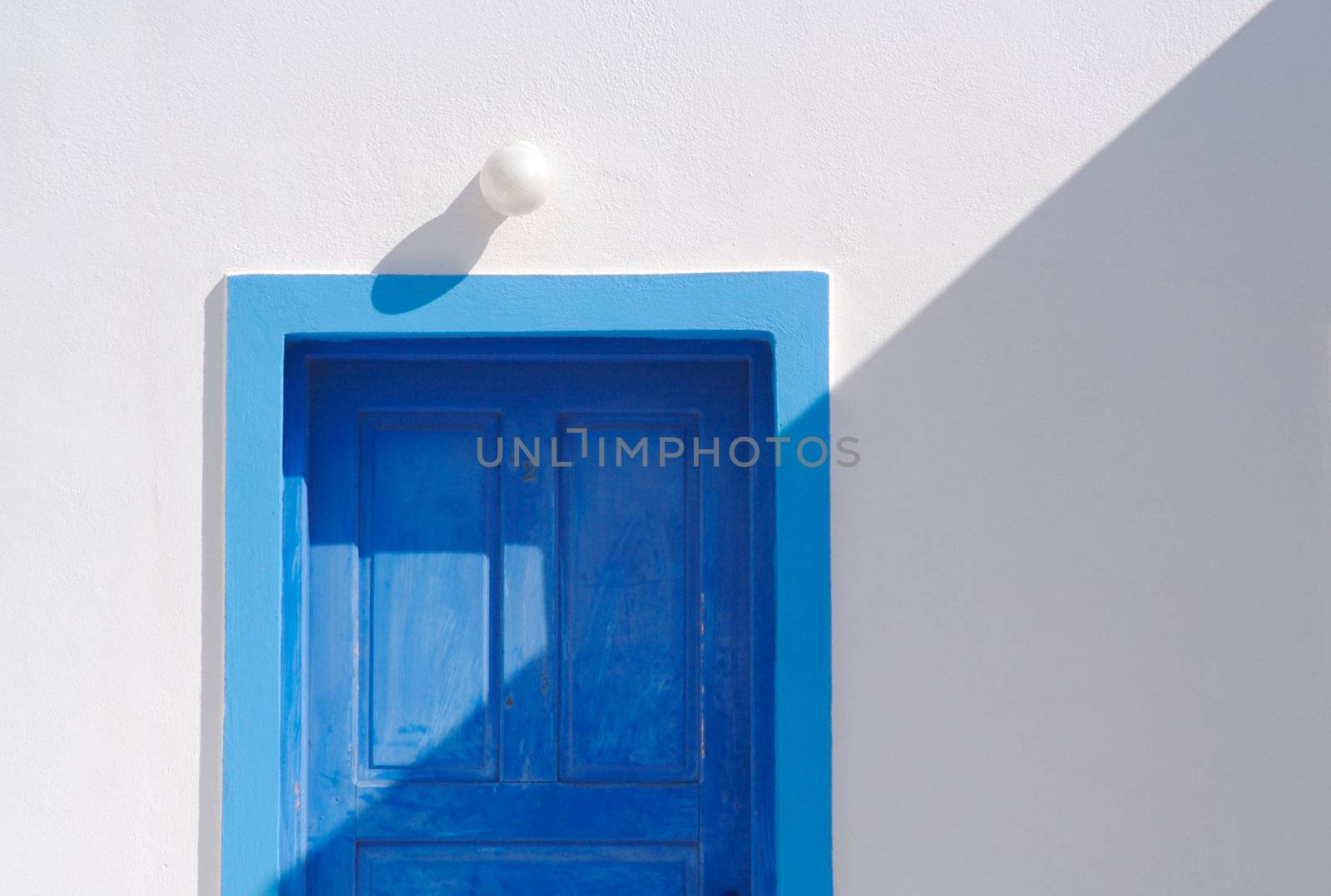 Abstract close-up of Santorini home wall, door and lamp. by Feverpitched