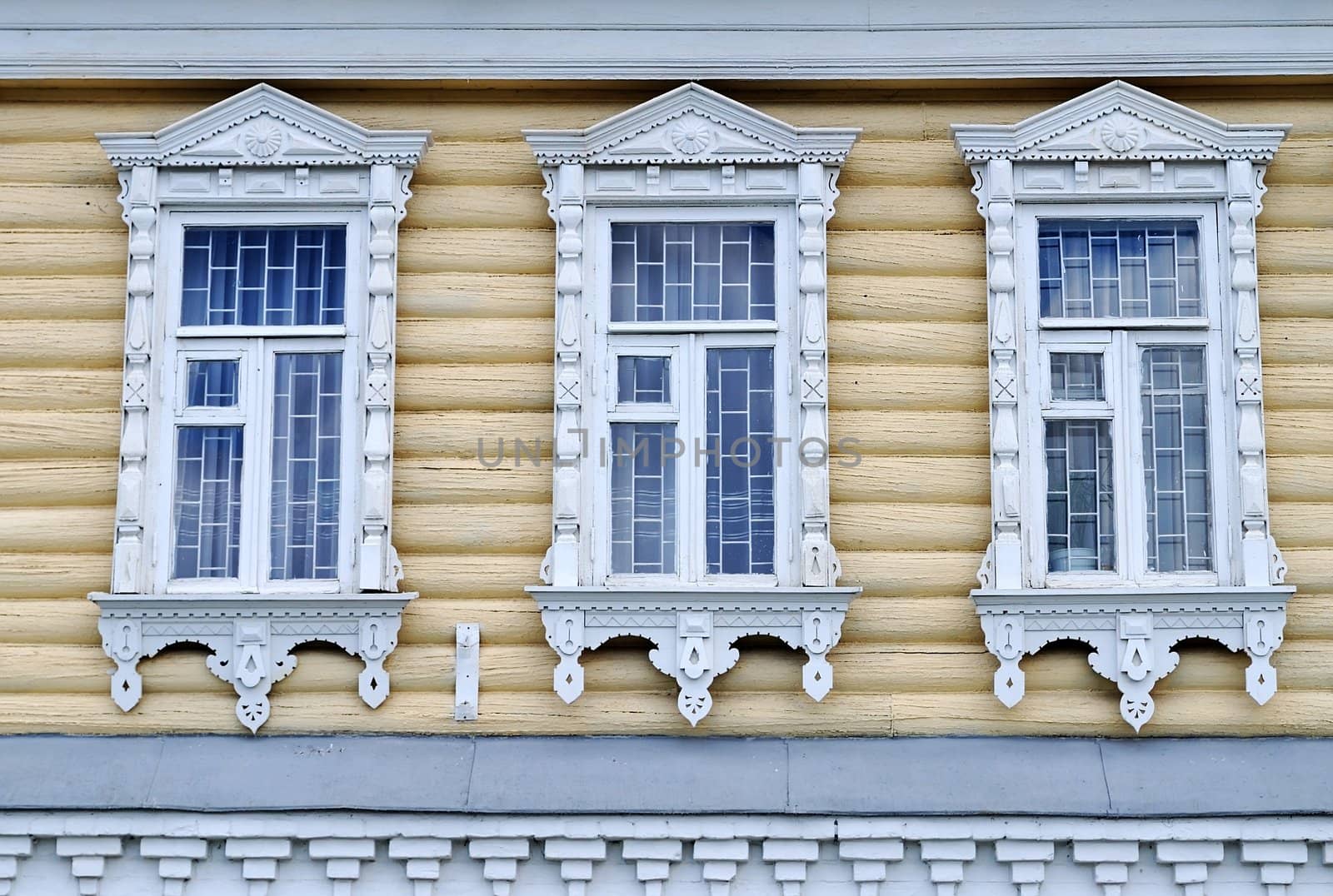 Windows of wooden building with traditional for Russian village trimming