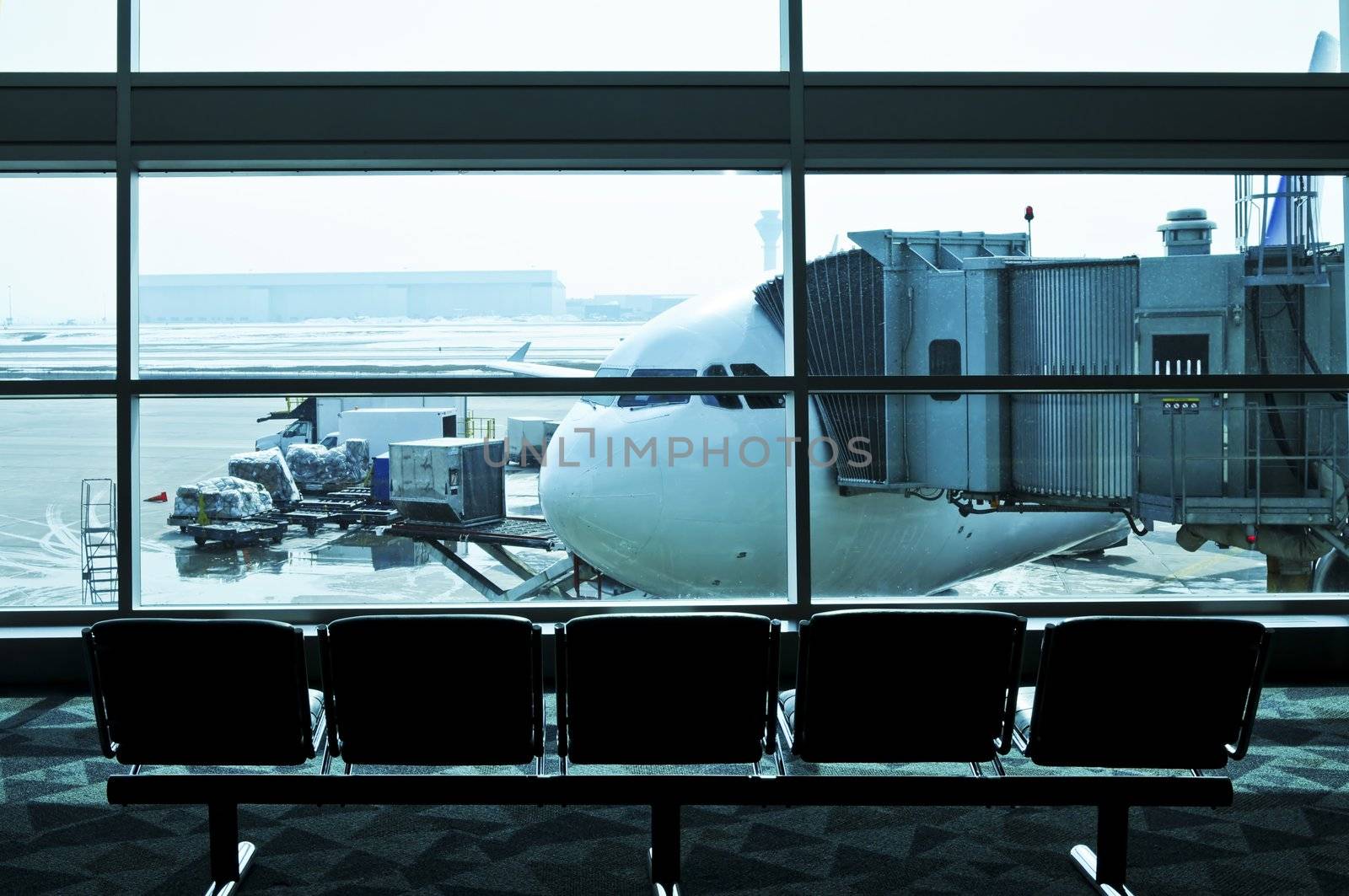 Waiting area of airport gate with airplane outside