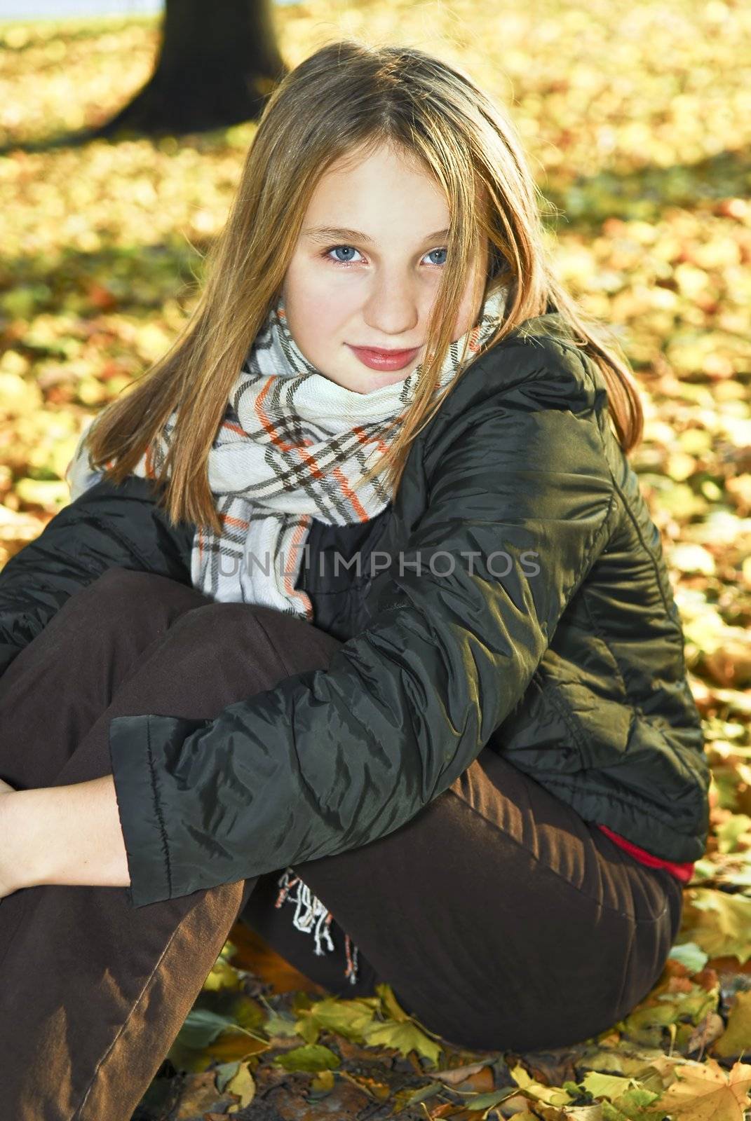 Portrait of a beautiful teenage girl in fall park