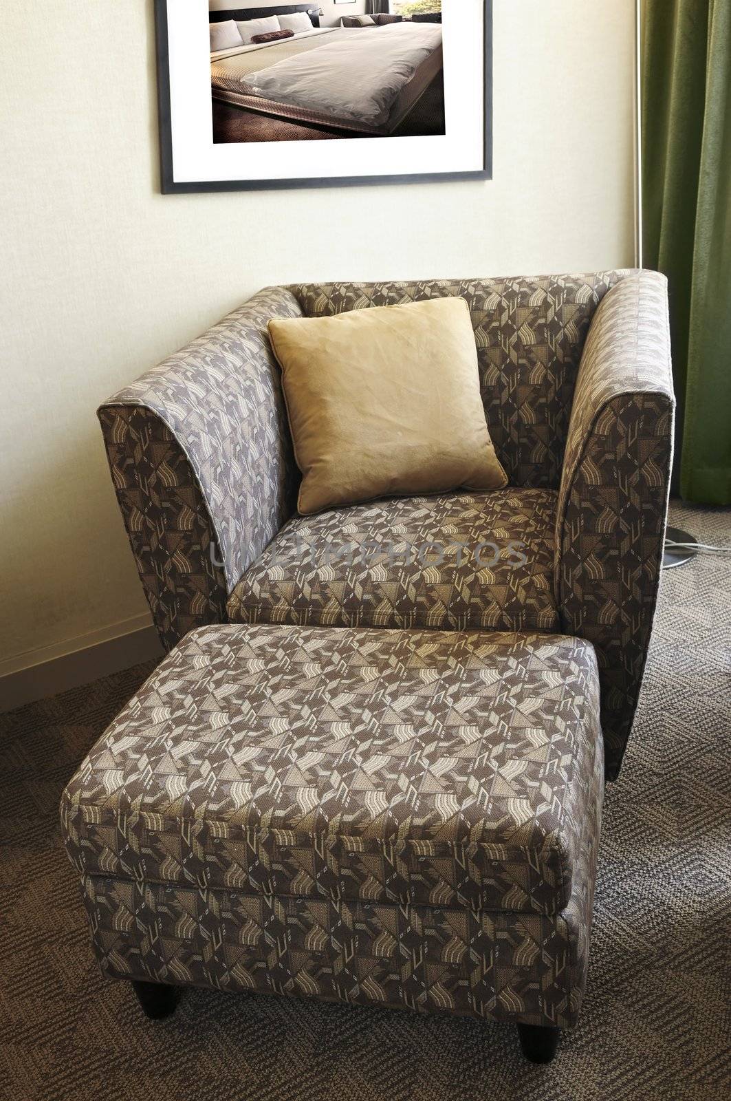 Comfortable armchair with cushion and ottoman. Photo on the wall is my own.