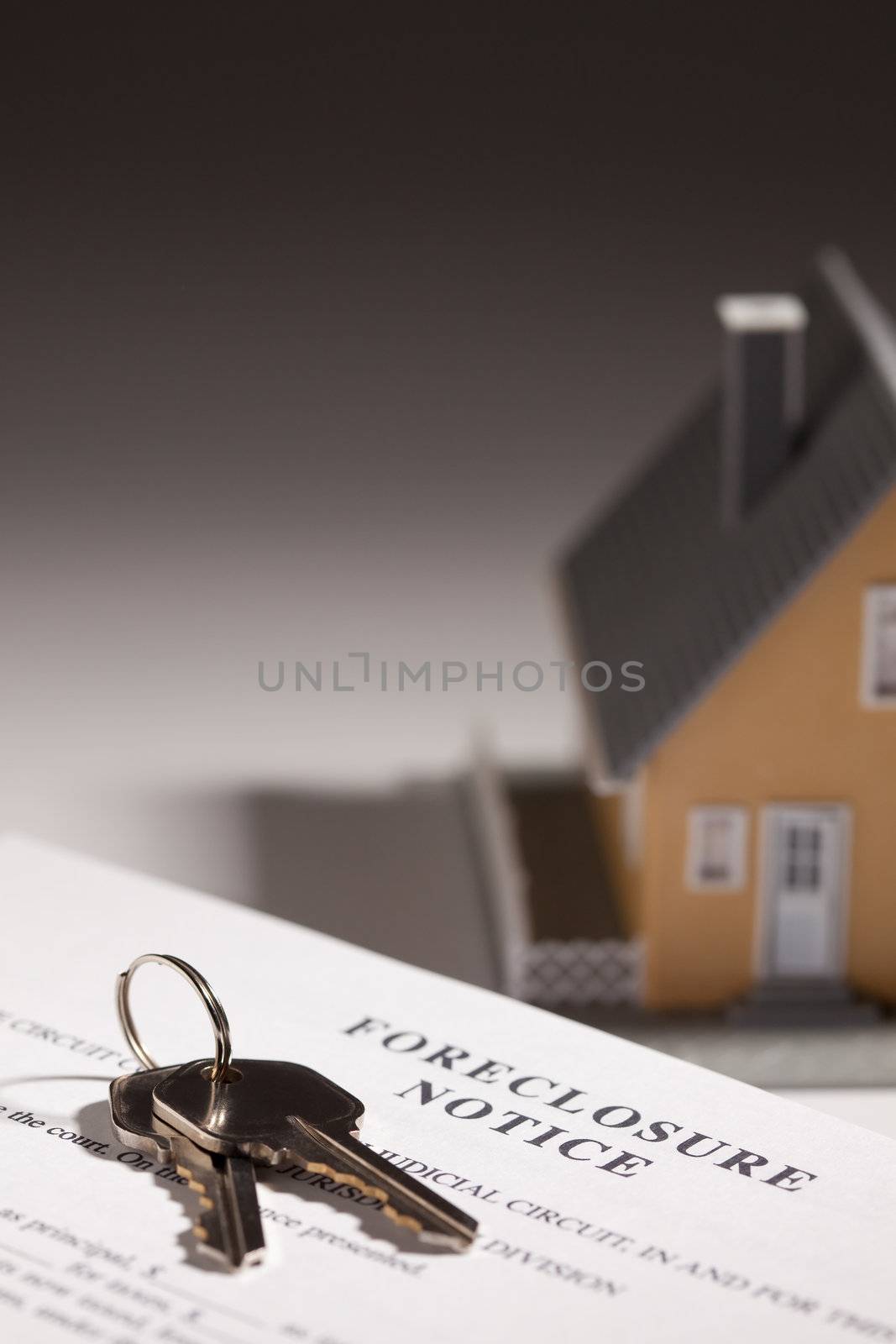 Foreclosure Notice, House Keys and Model Home on Gradated Background with Selective Focus.