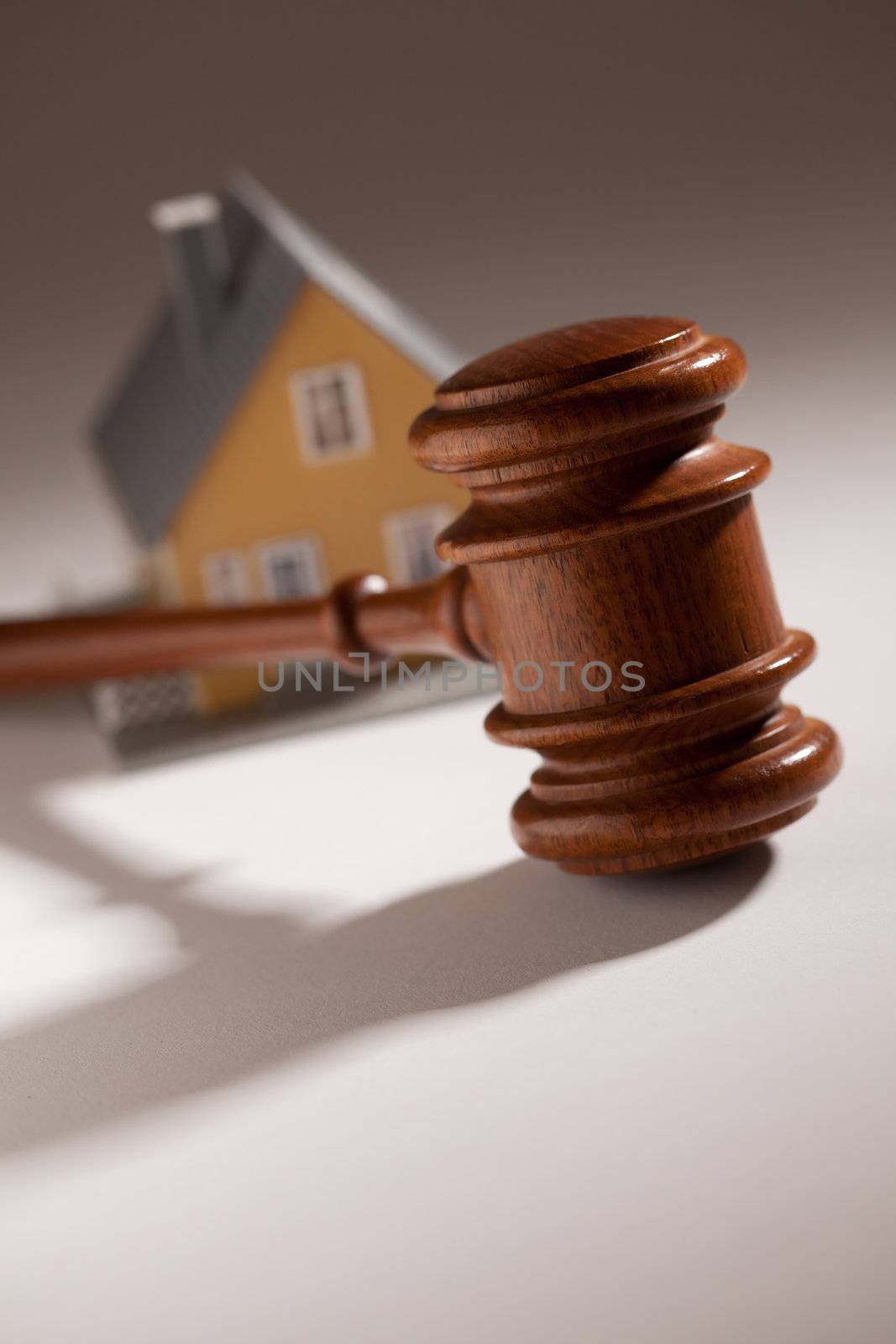 Gavel and Model Home on Gradated Background with Selective Focus.