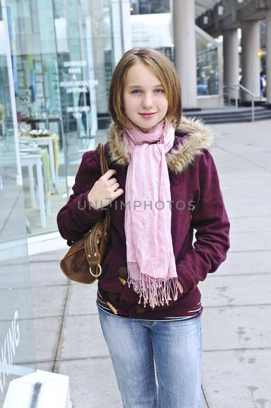 Teenage girl window shopping on city street