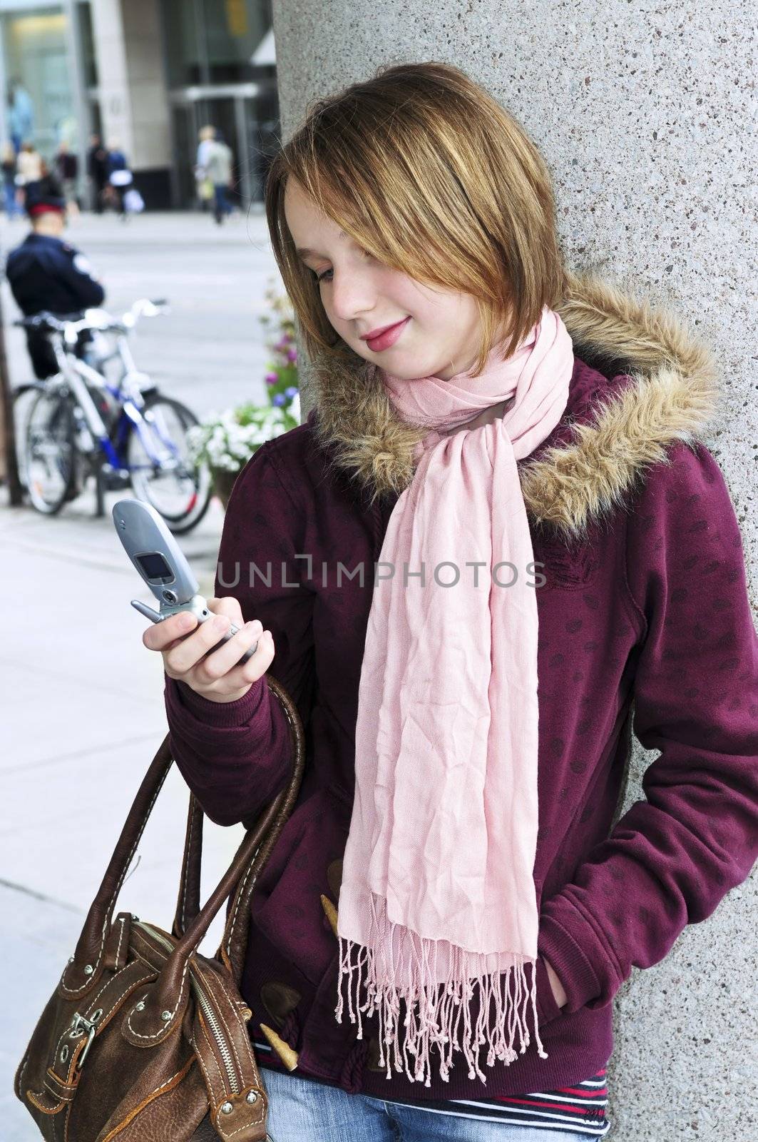 Teenage girl text messaging on cell phone by elenathewise