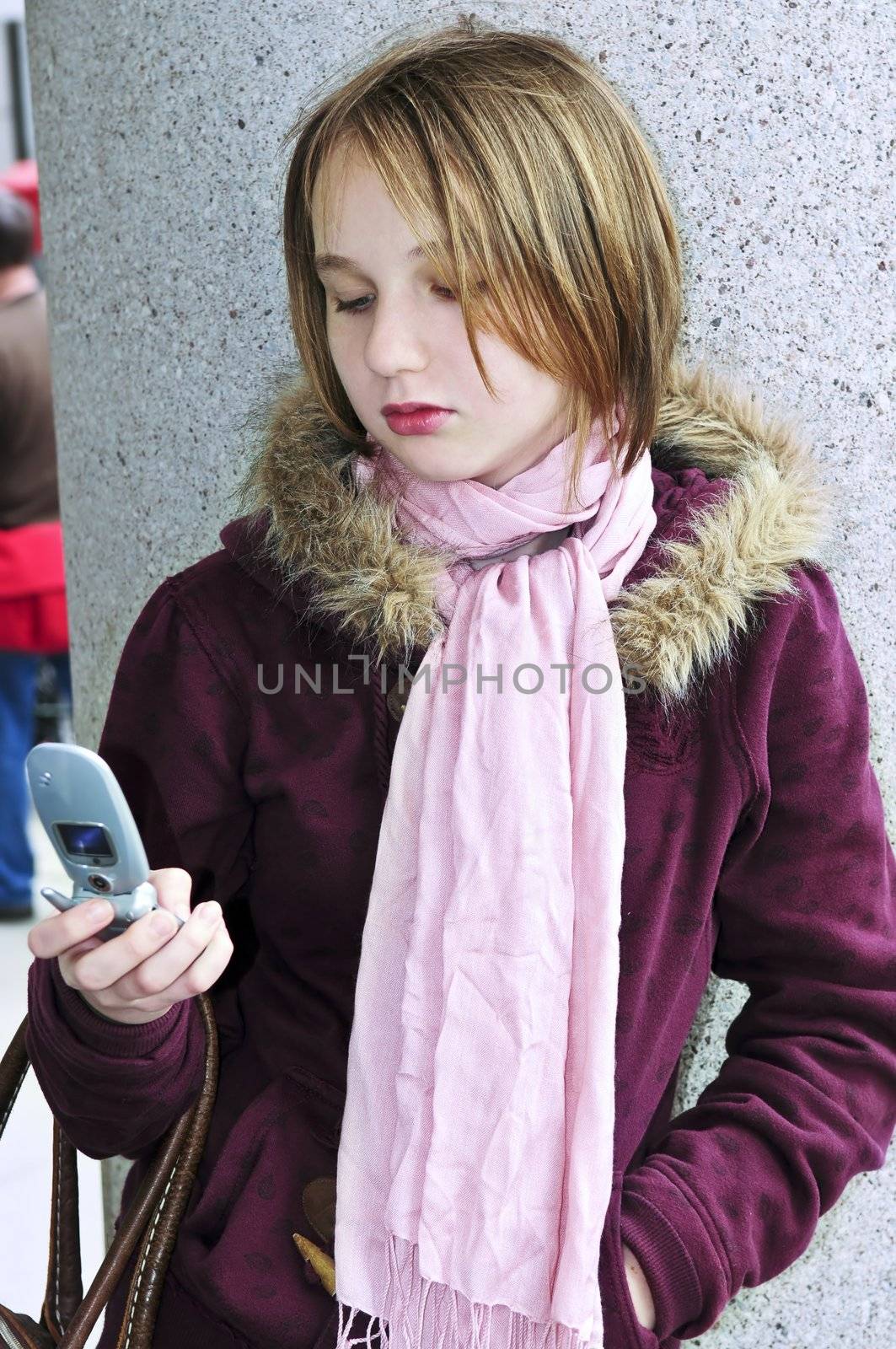 Teenage girl text messaging on cell phone by elenathewise