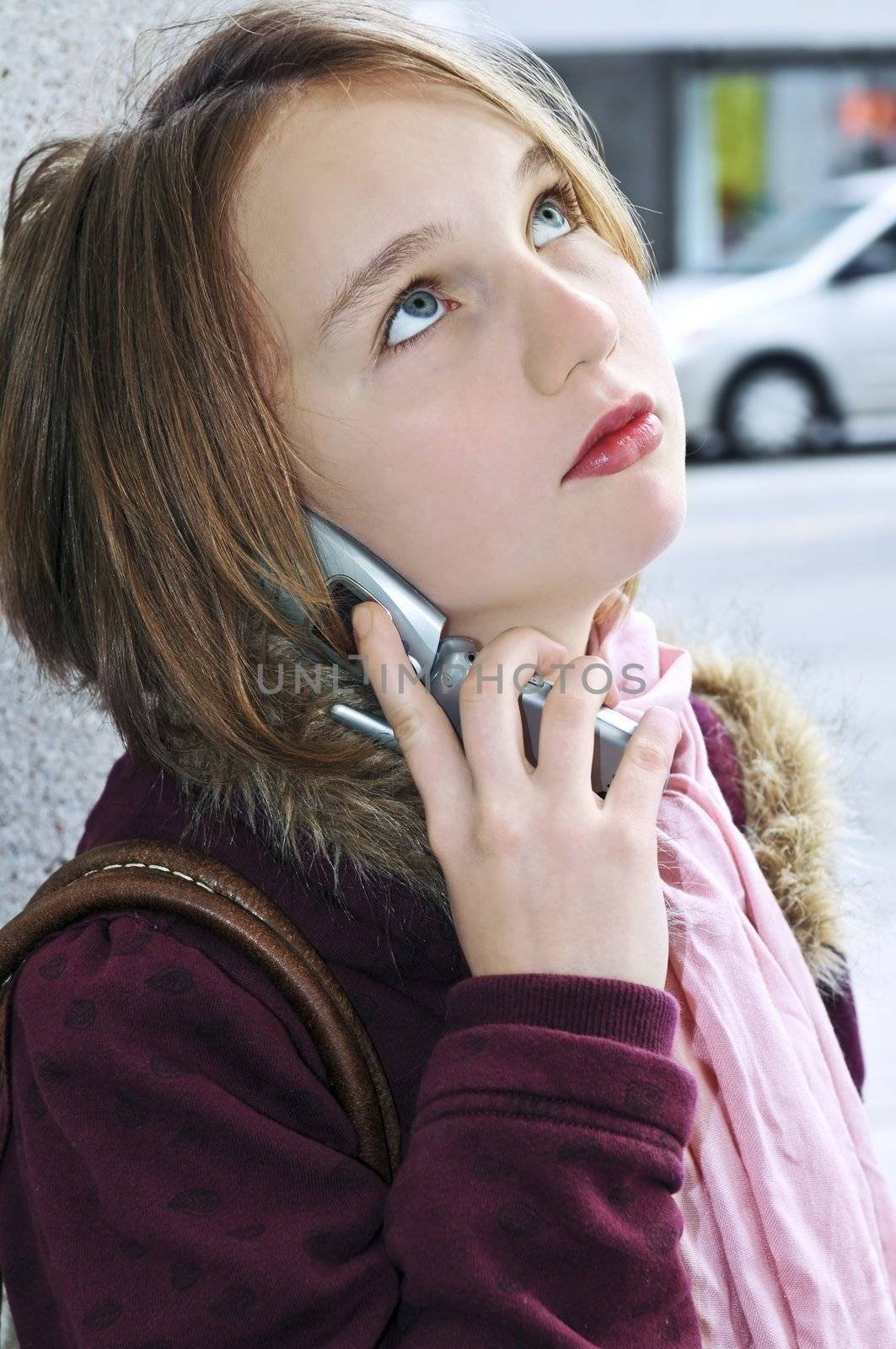 Teenage girl talking on cell phone by elenathewise