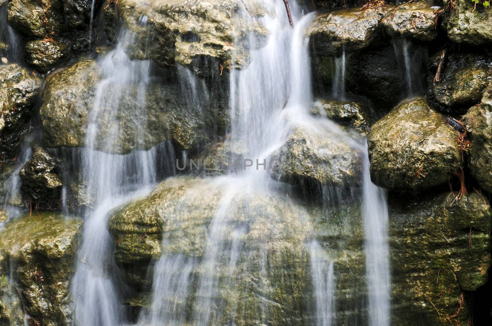Waterfall over natural stones in japanese zen garden
