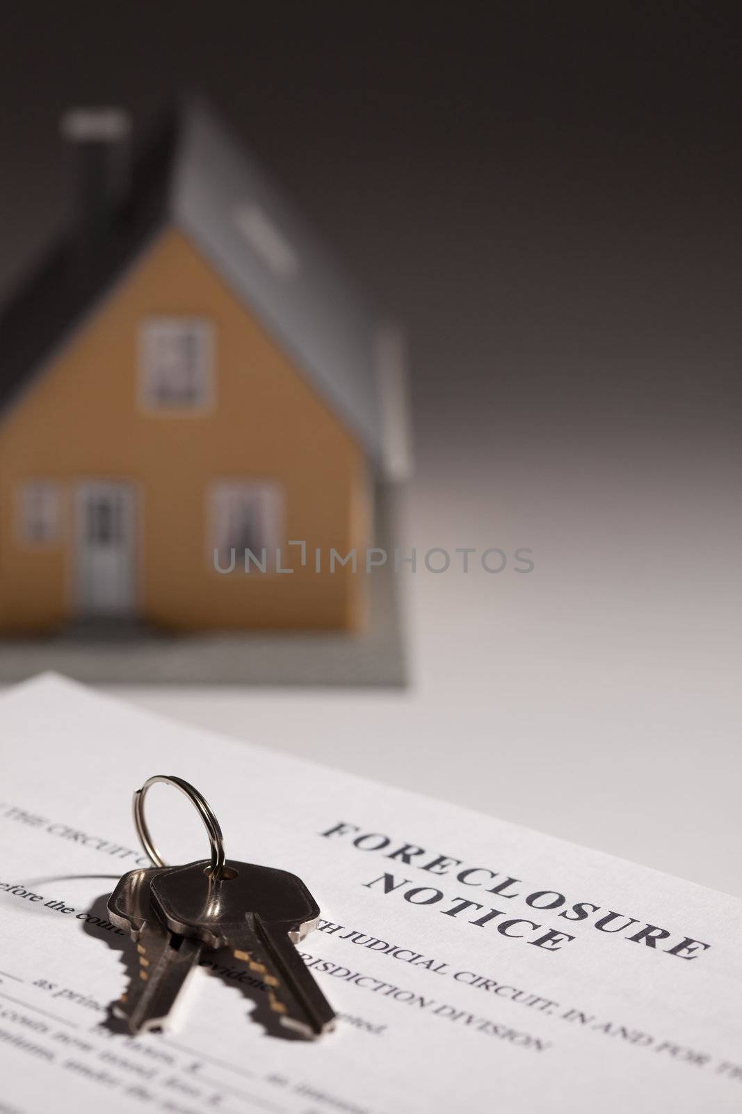 Foreclosure Notice, House Keys and Model Home on Gradated Background with Selective Focus.