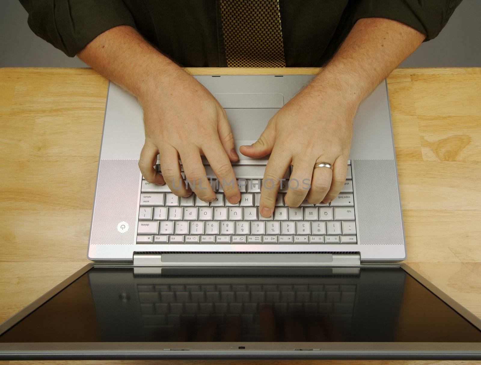 Man Using Laptop on Wooden Desk