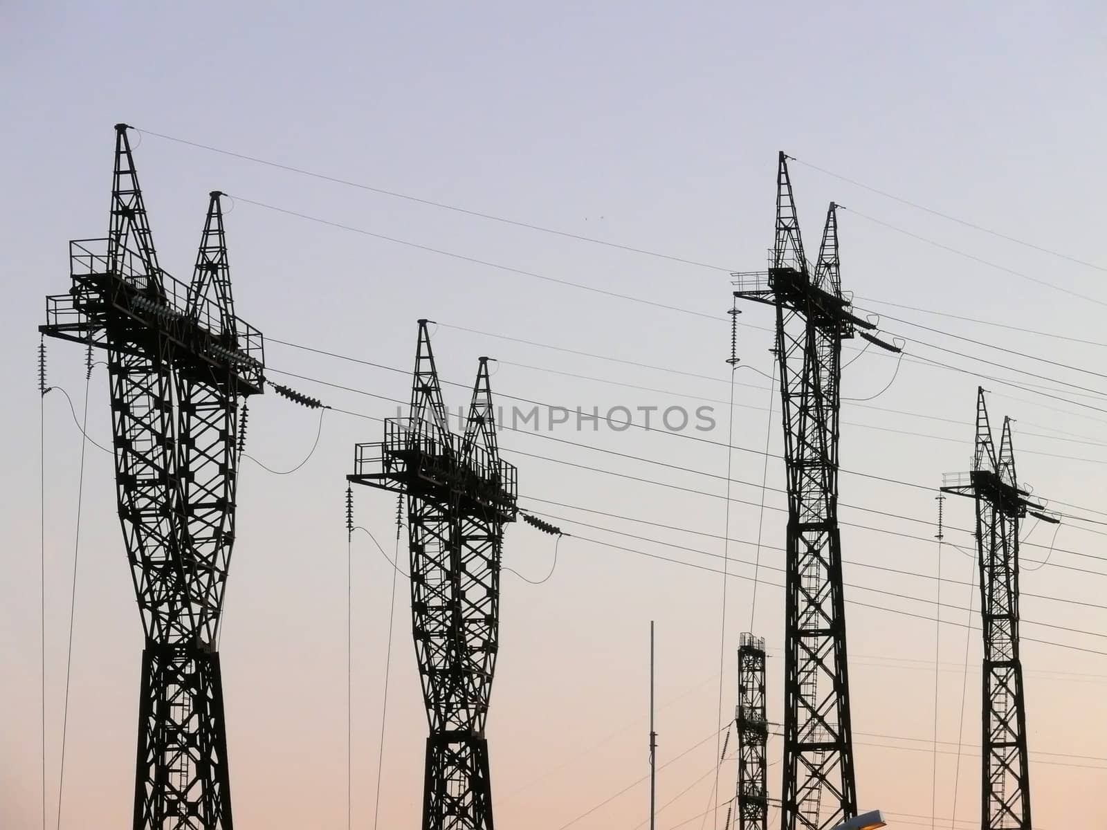 Rows of electricity pylons in bright sunshine