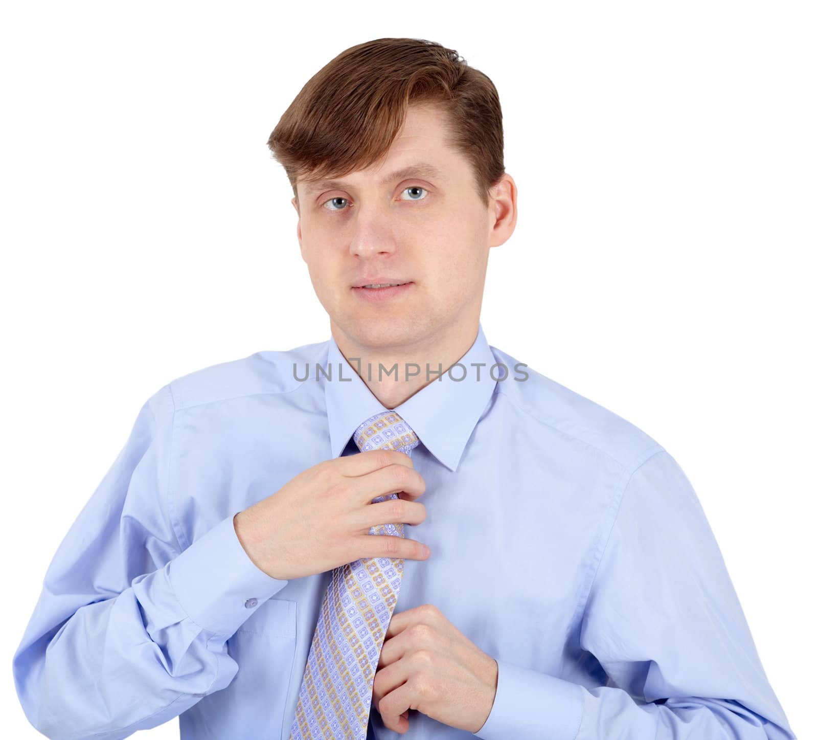 Young man adjusts his tie isolated on a white background