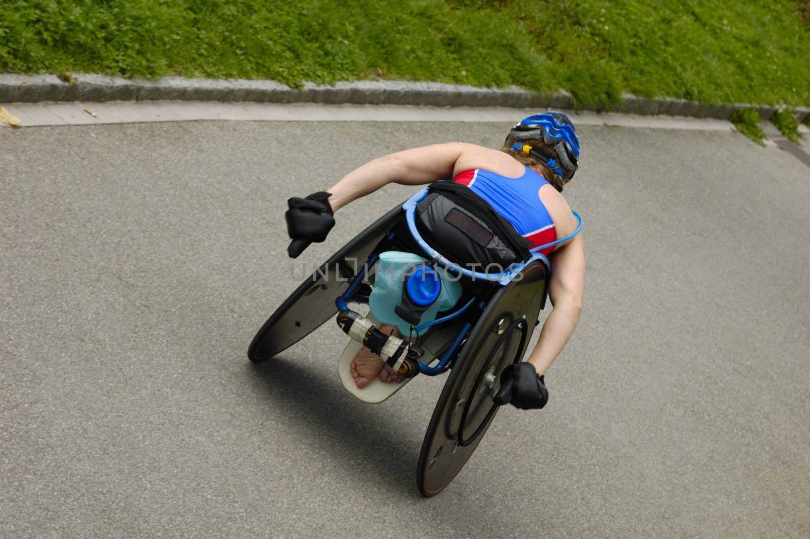 A wheelchair athlete taking part in a marathon race. Slight motion blur on her hands.