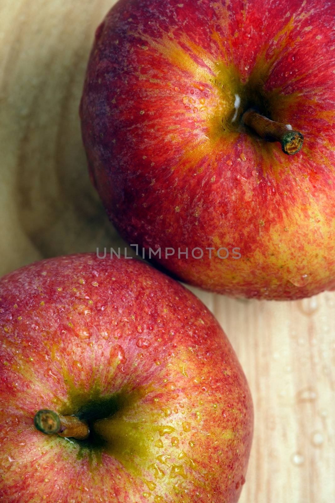 The tops of two apples on a wooden table. Shallow depth of field.
