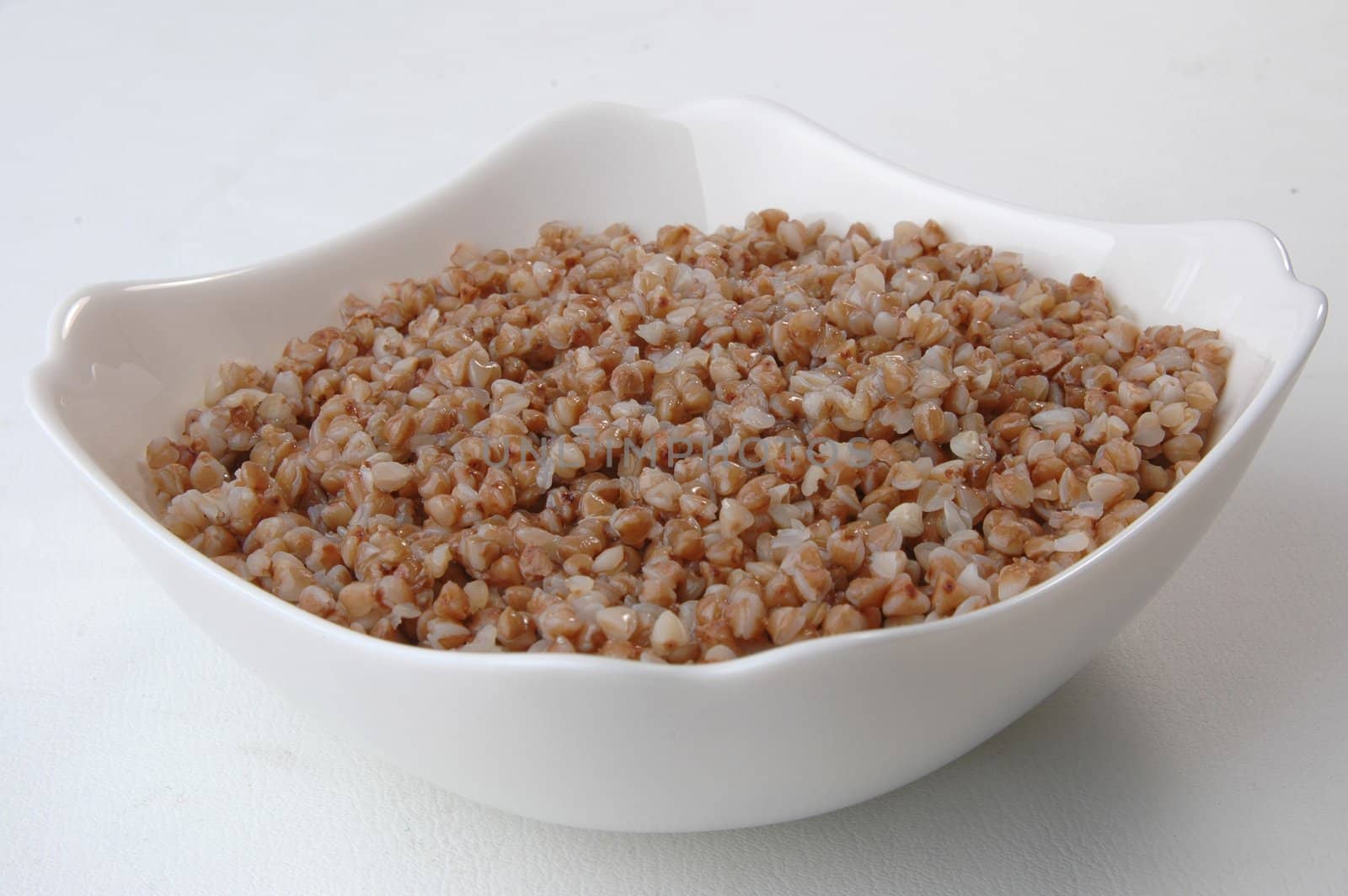 groats porridge in  plate on white