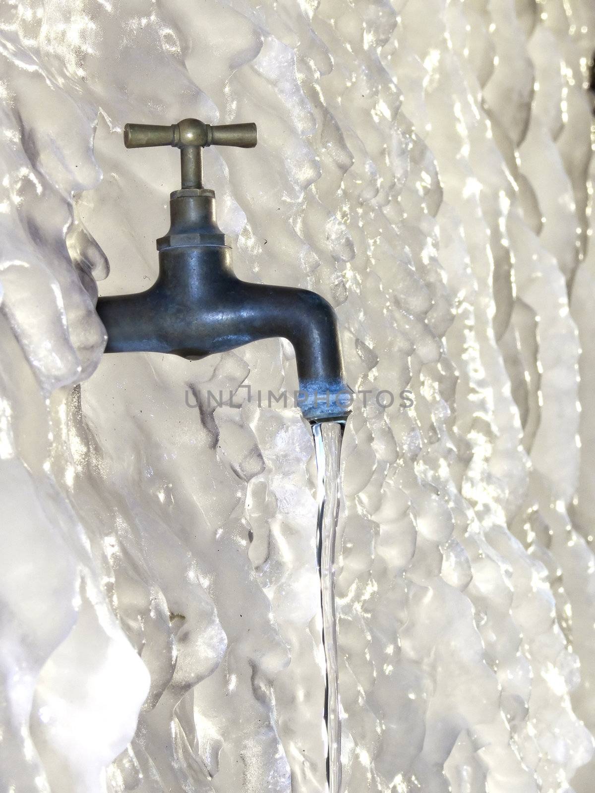 a tap on a frozen wall