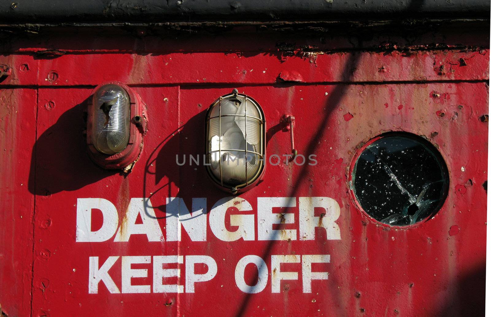Danger warning on rusty red painted metal 
