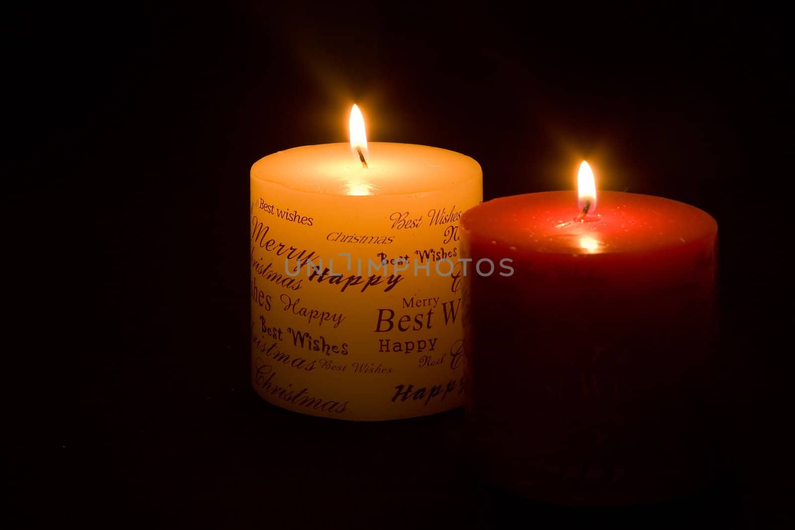 Lit Christmas candles on black background