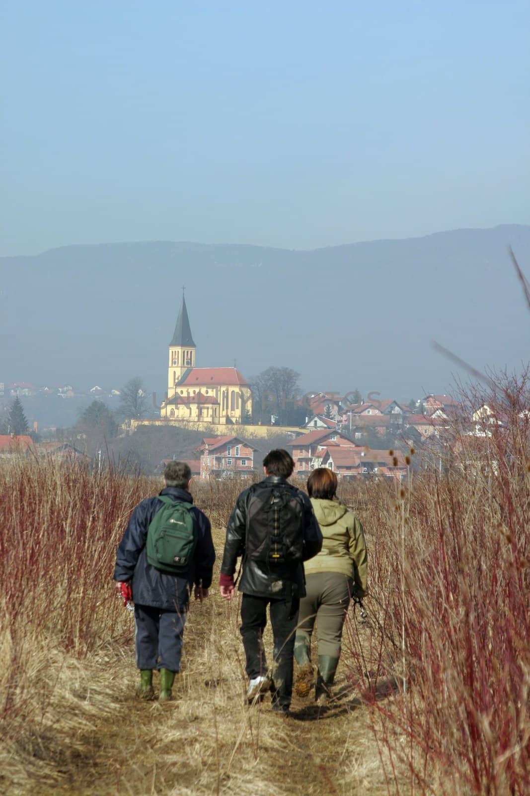 Three people walking in the fields