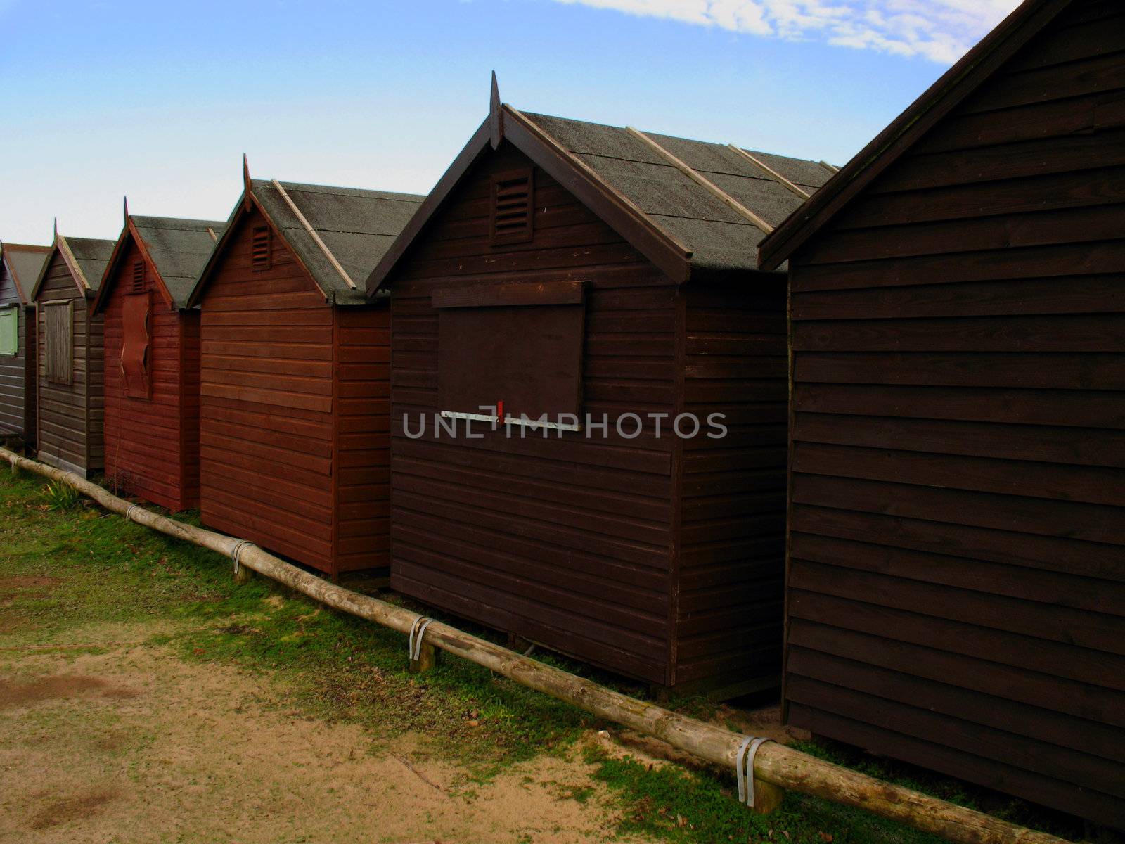 Close view of row of beach huts on sand dunes. Deserted during the winter months.