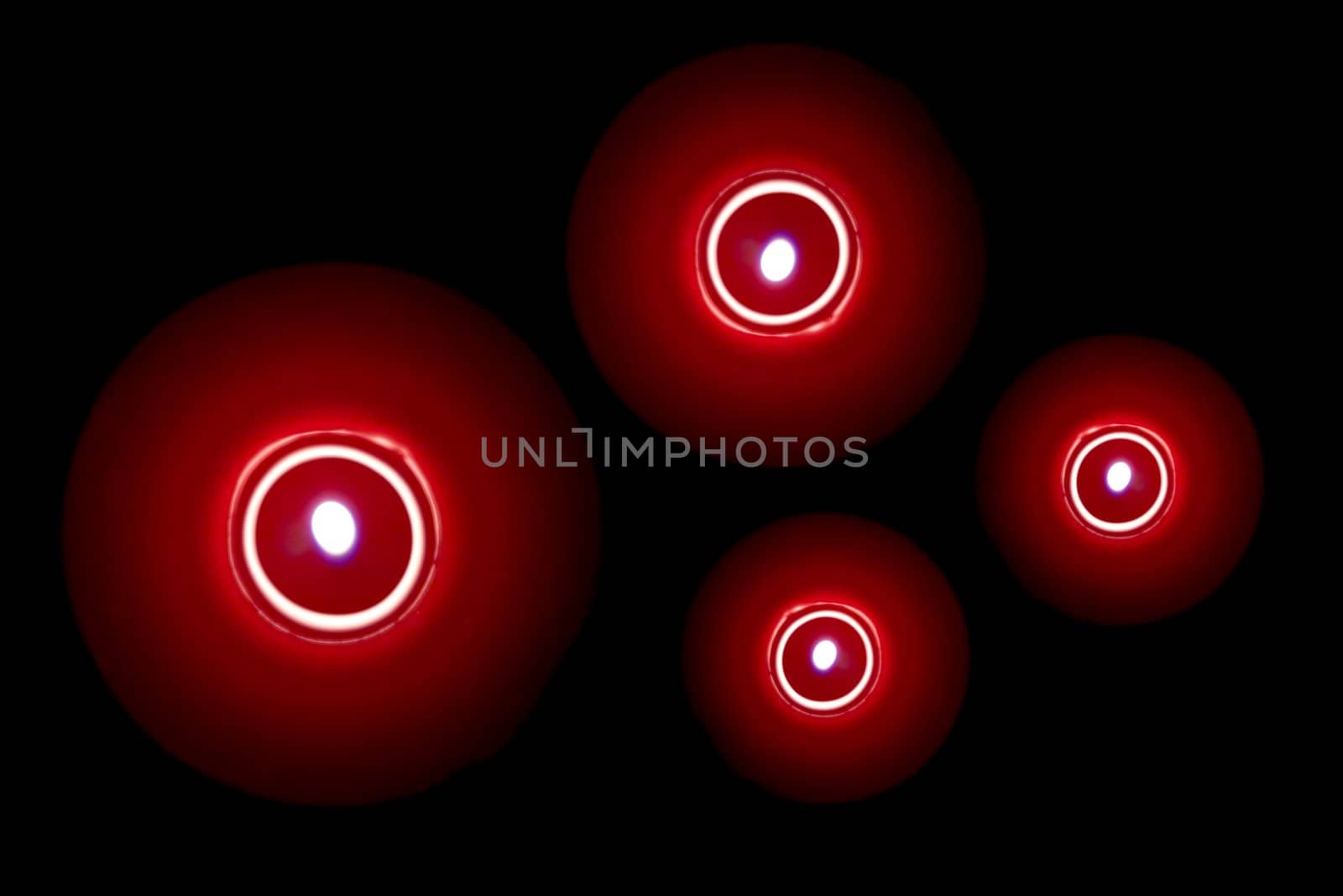 Group of candles photographed from above. Abstract on black background