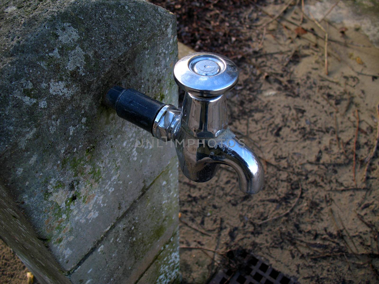 Outside water tap on beach on concrete support