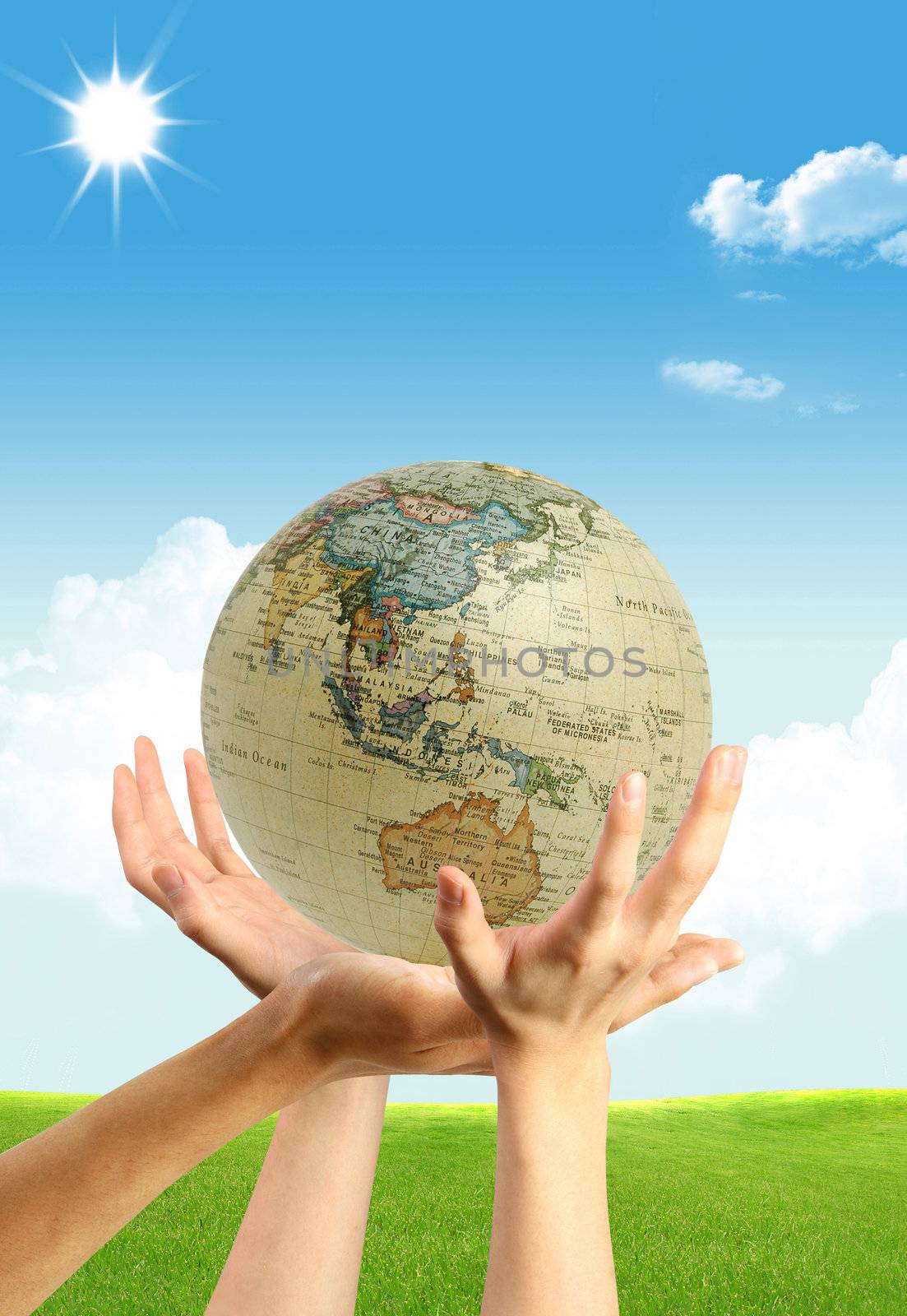 Three hands and a globe on the blue shining sky background