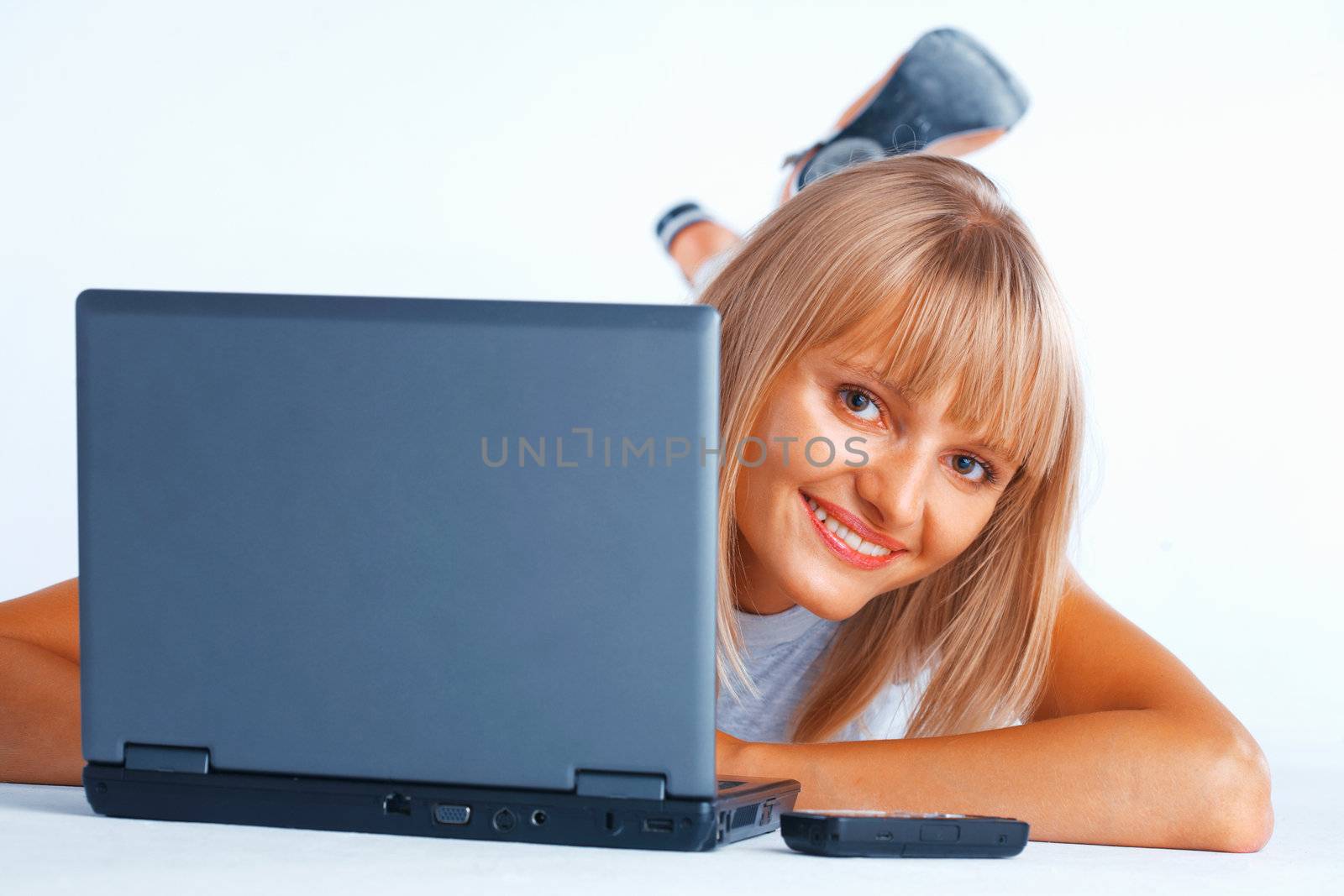 Young women peeping out from the laptop, laing on the floor