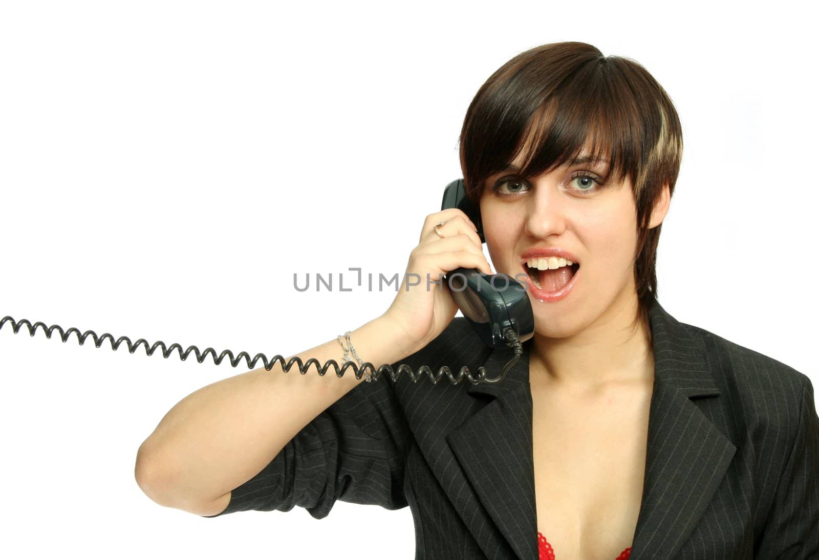 The young nice girl speaks by phone with a smile, isolated on white