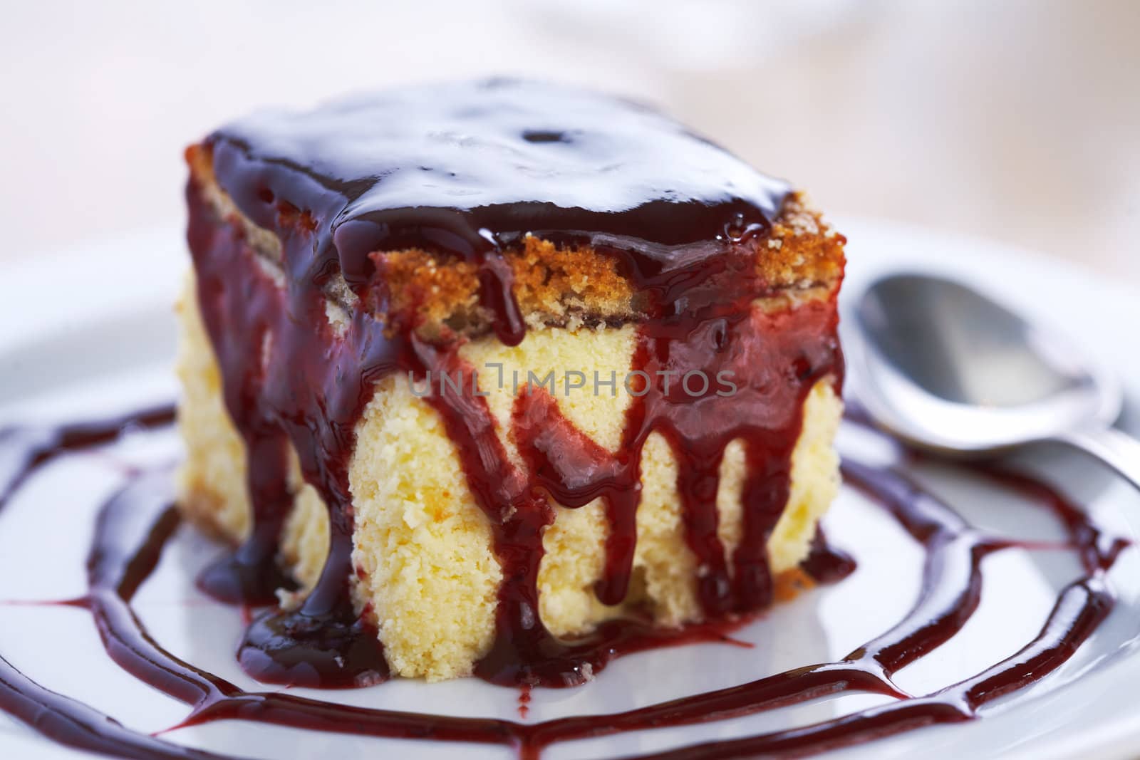 Closeup of cheese cake with jam on a plate.
