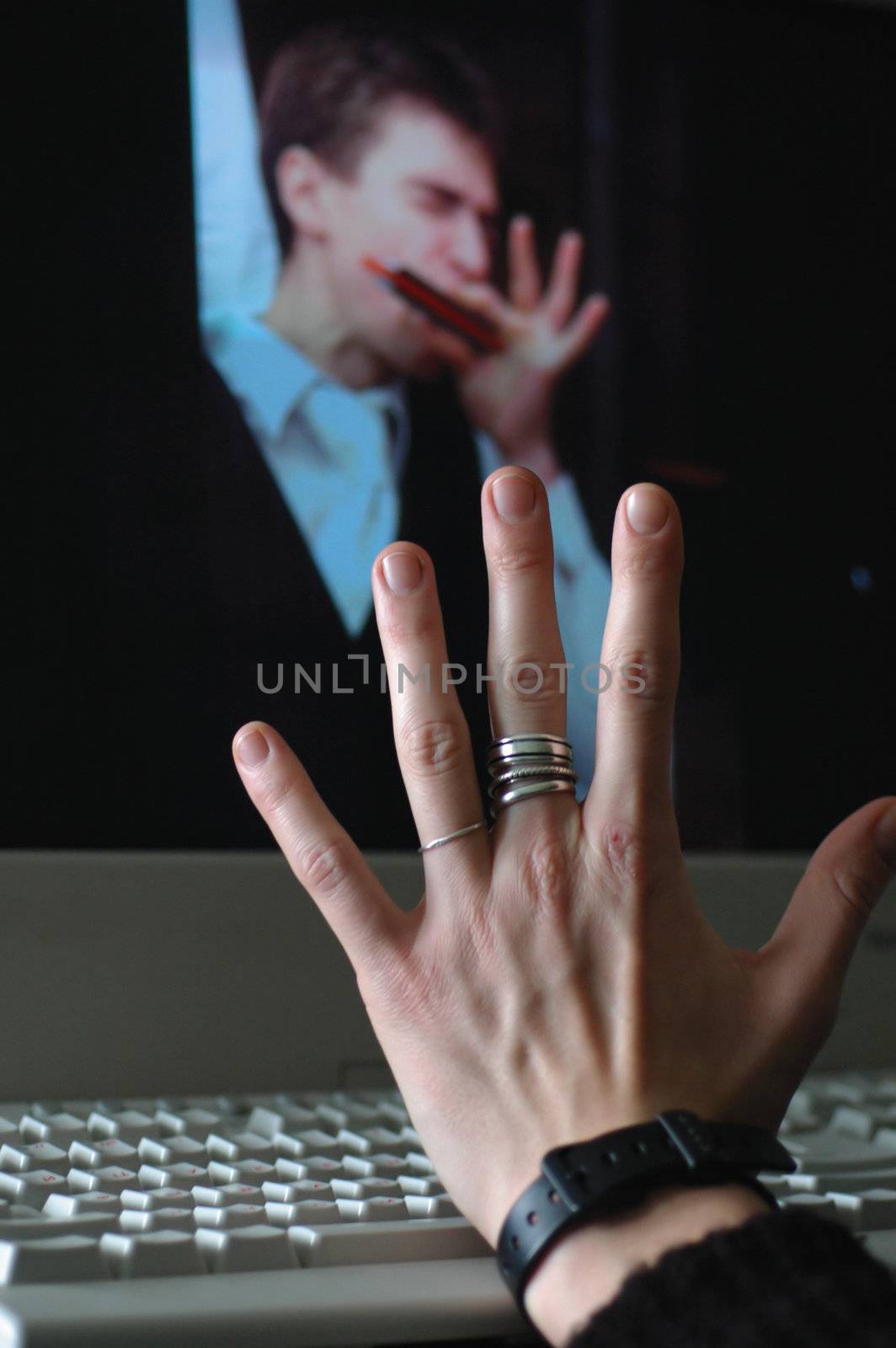 Woman's hand with silver rings on a monitor background 