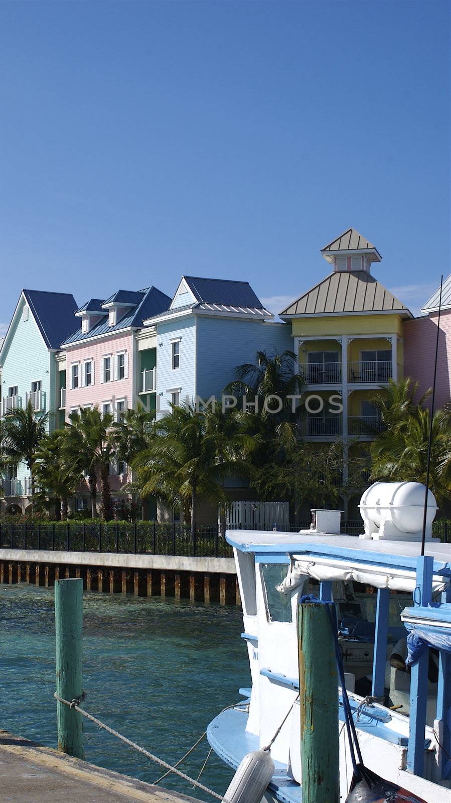 Taken from the ferry port in Nassau along the ocean side, featuring multicoloured houses against a blue sky