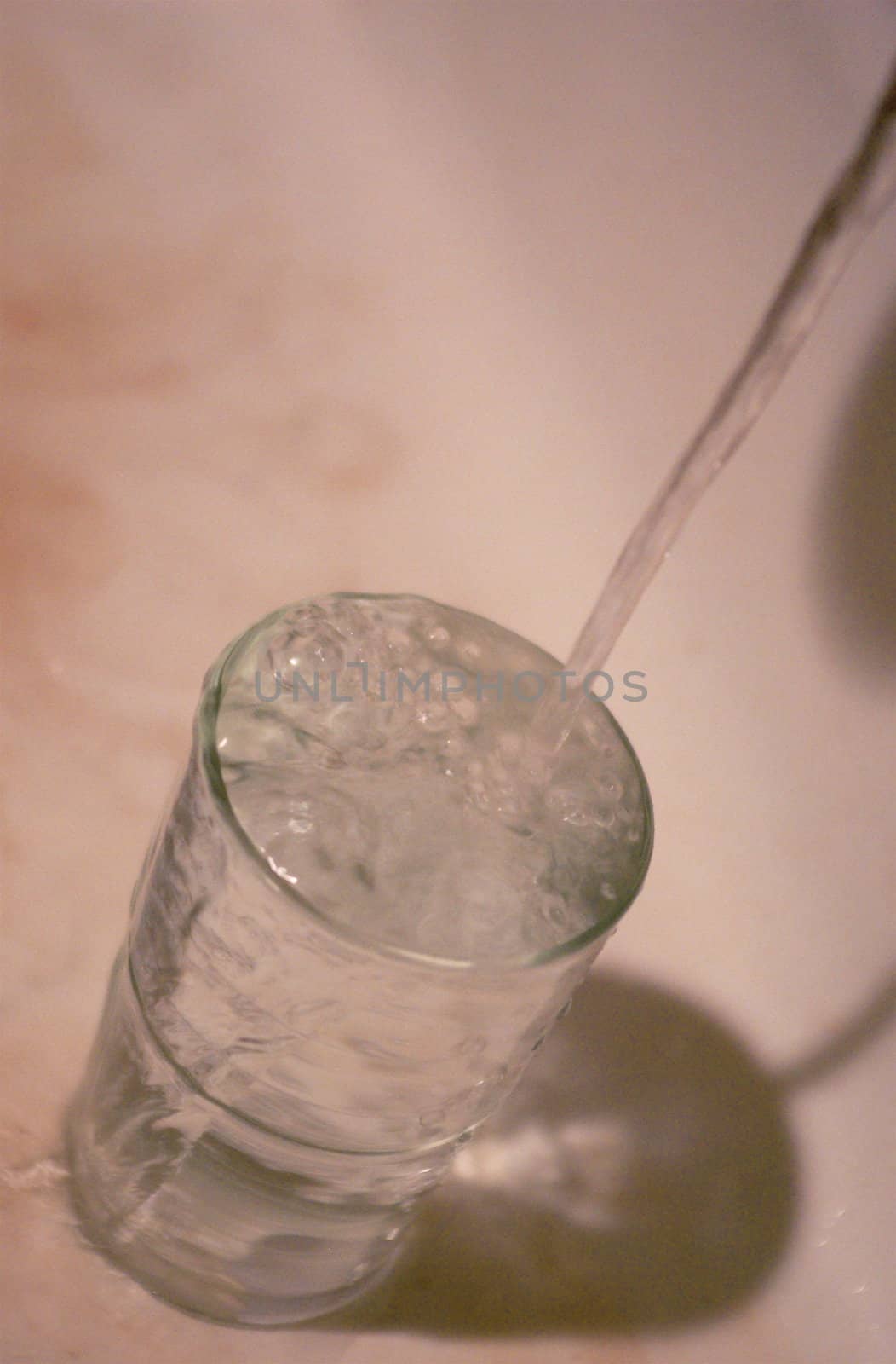 Glass being filled with water from a running tap