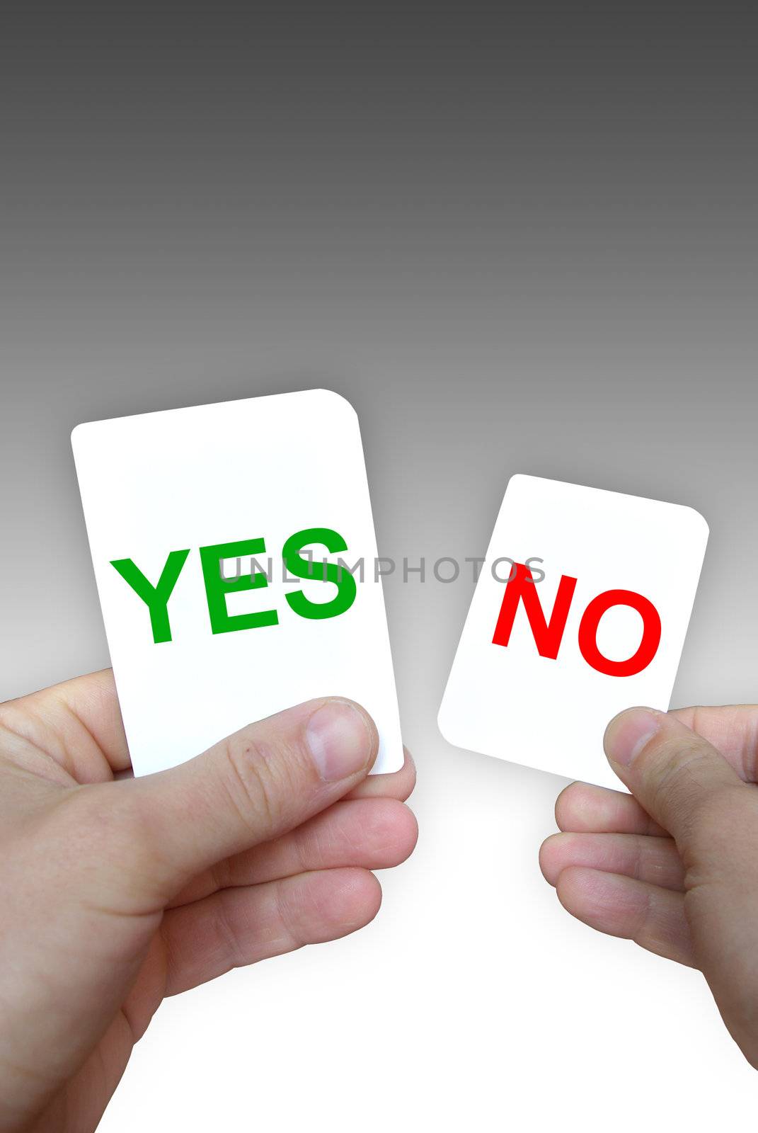 Photo of coloured yes-no cards in hands on a grey background