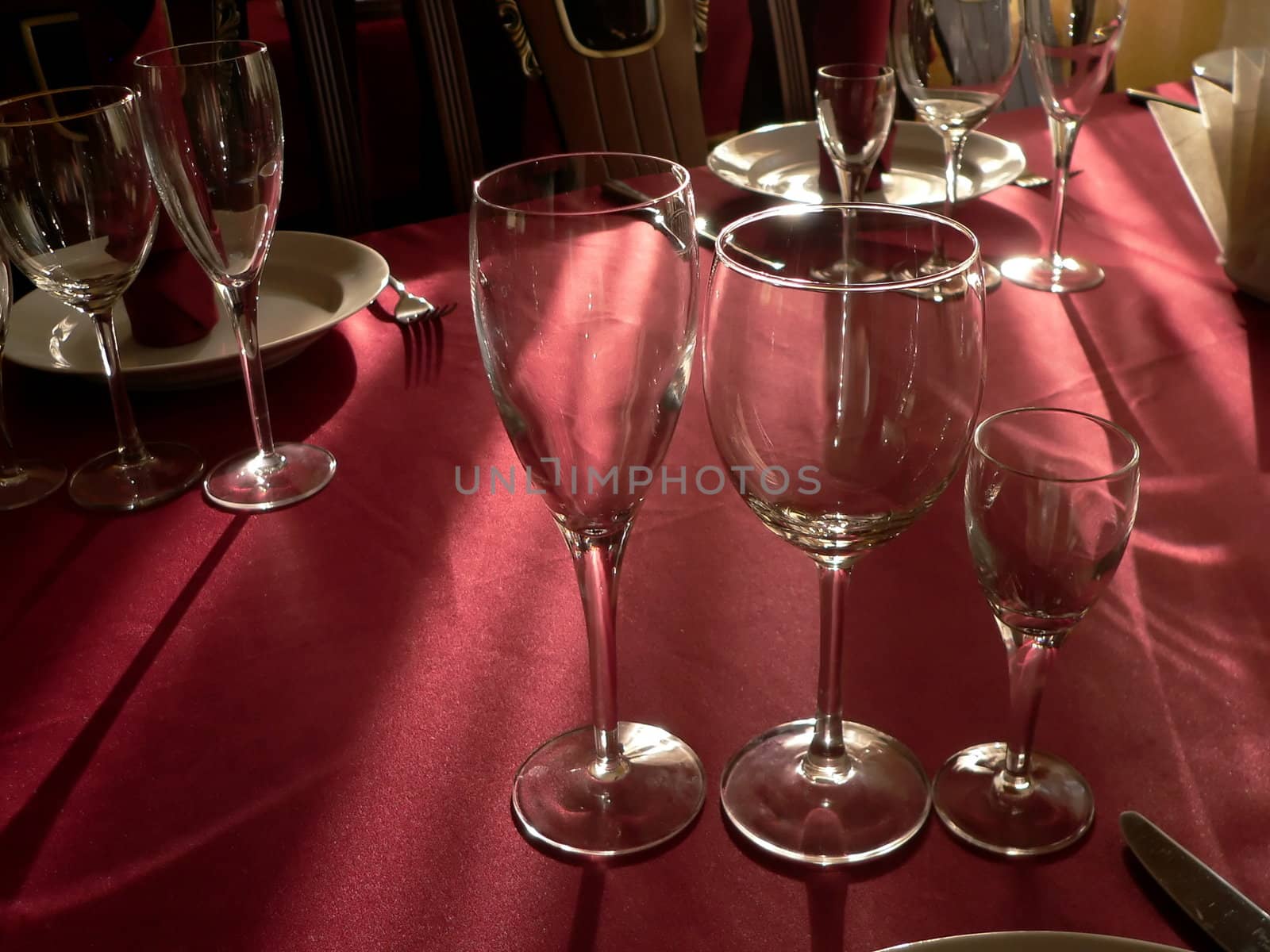 Wineglasses on purple tablecloth. To lay the table.