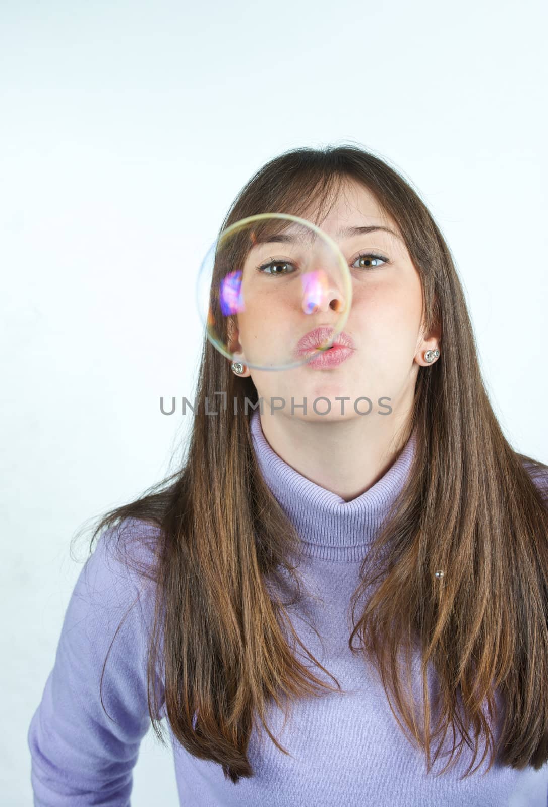 Pretty woman blowing in the soap to create some bubbles