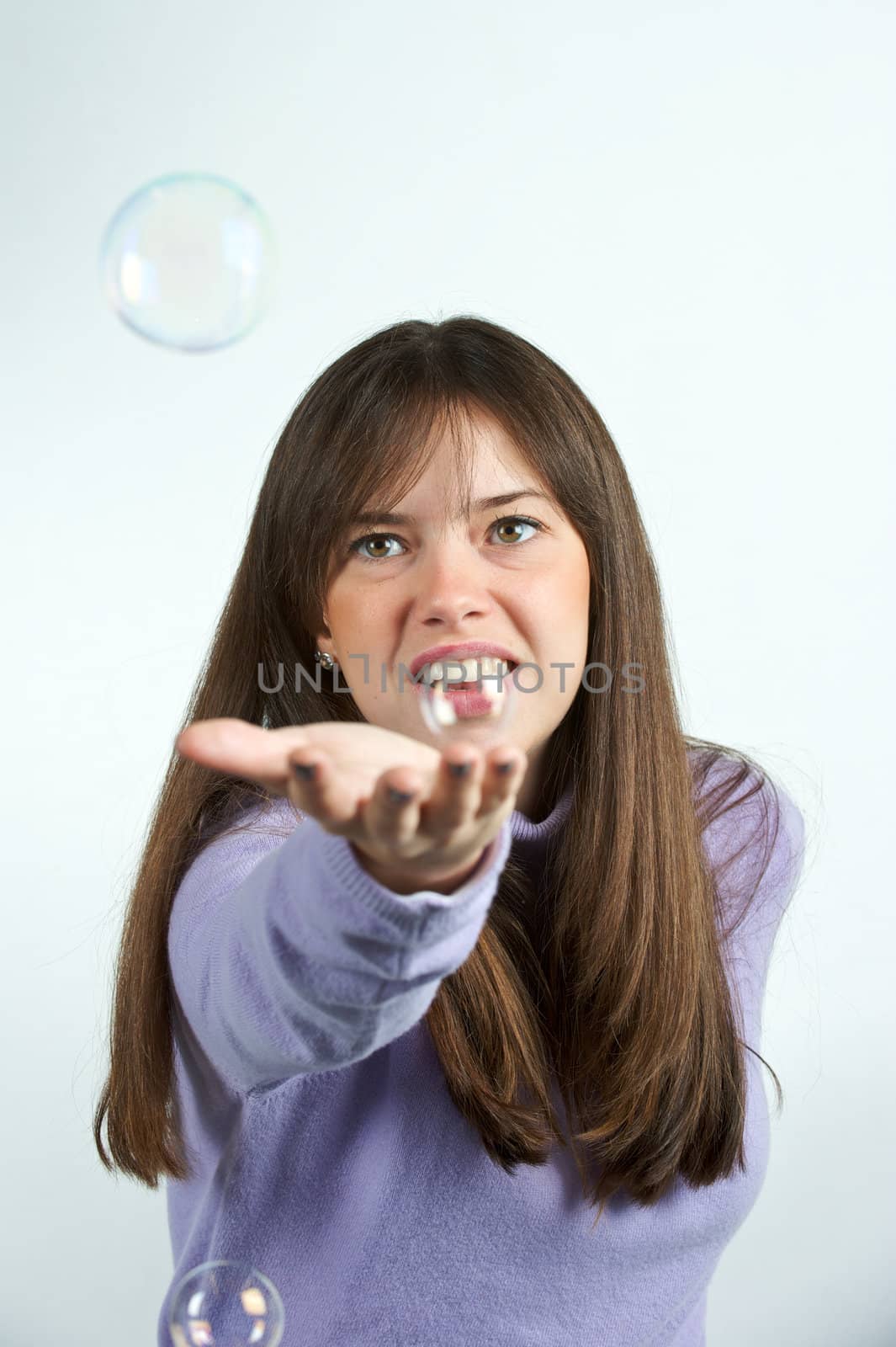 Pretty woman blowing in the soap to create some bubbles