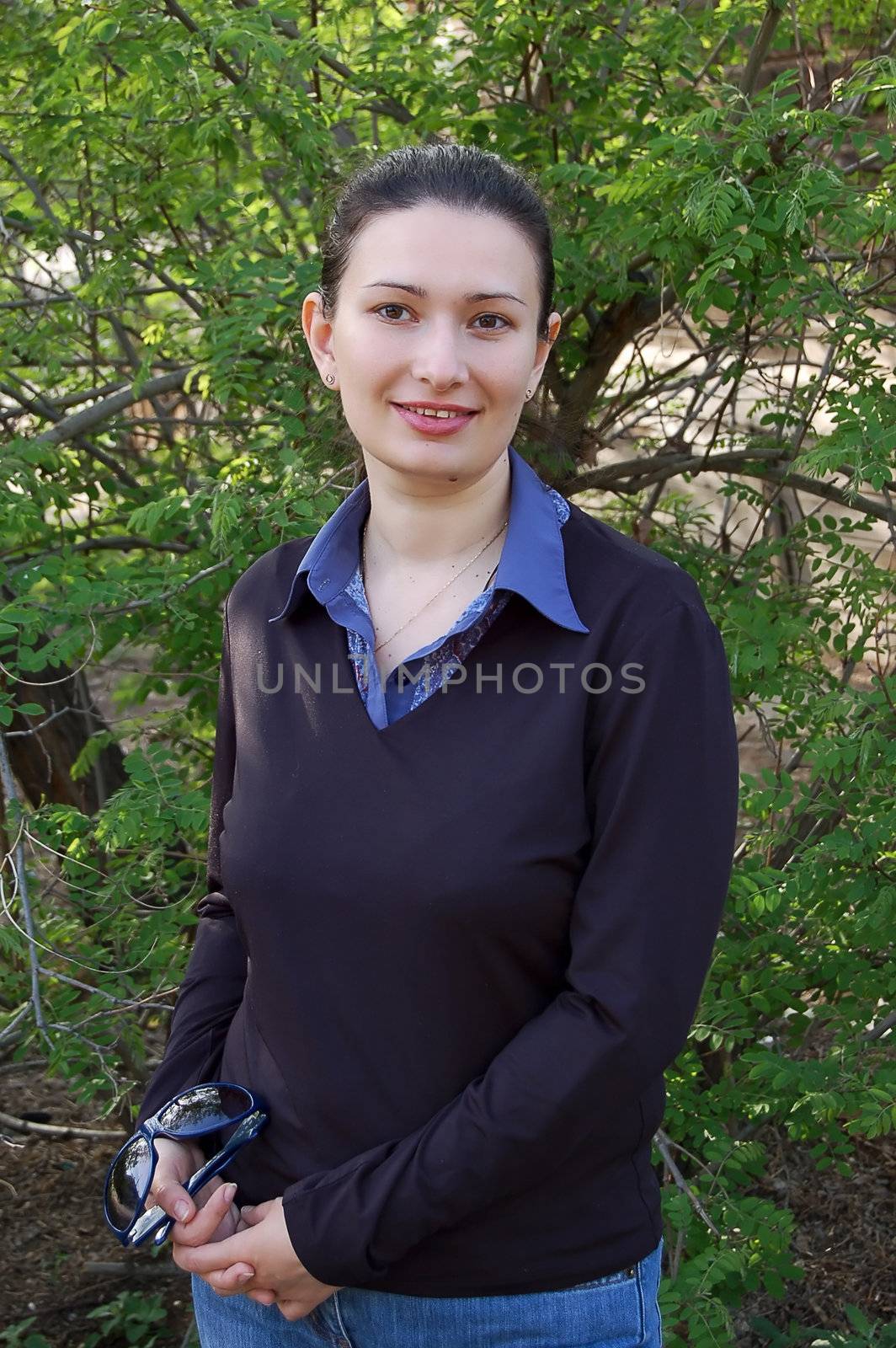 attractive young brunette and spring trees in the garden