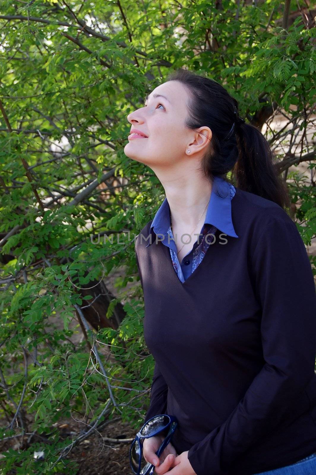 attractive young brunette and spring trees in the garden