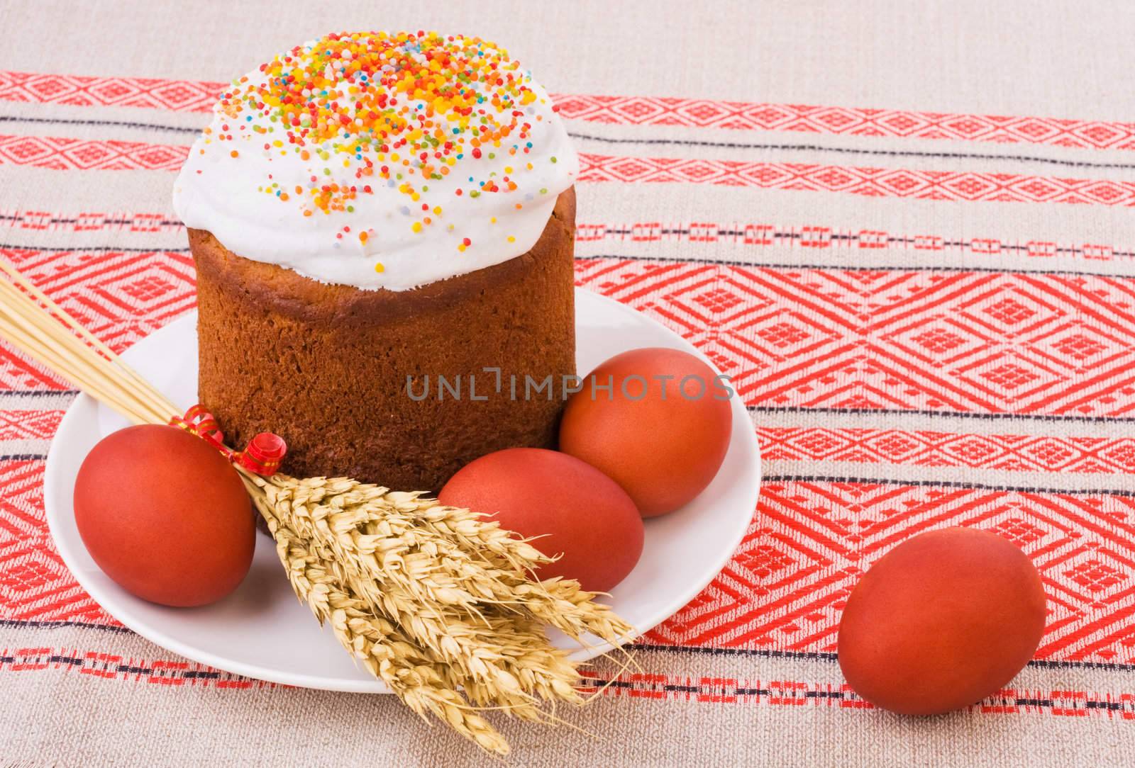 Easter Cake, Painted Eggs and Ears of Wheat on traditional tablecloth