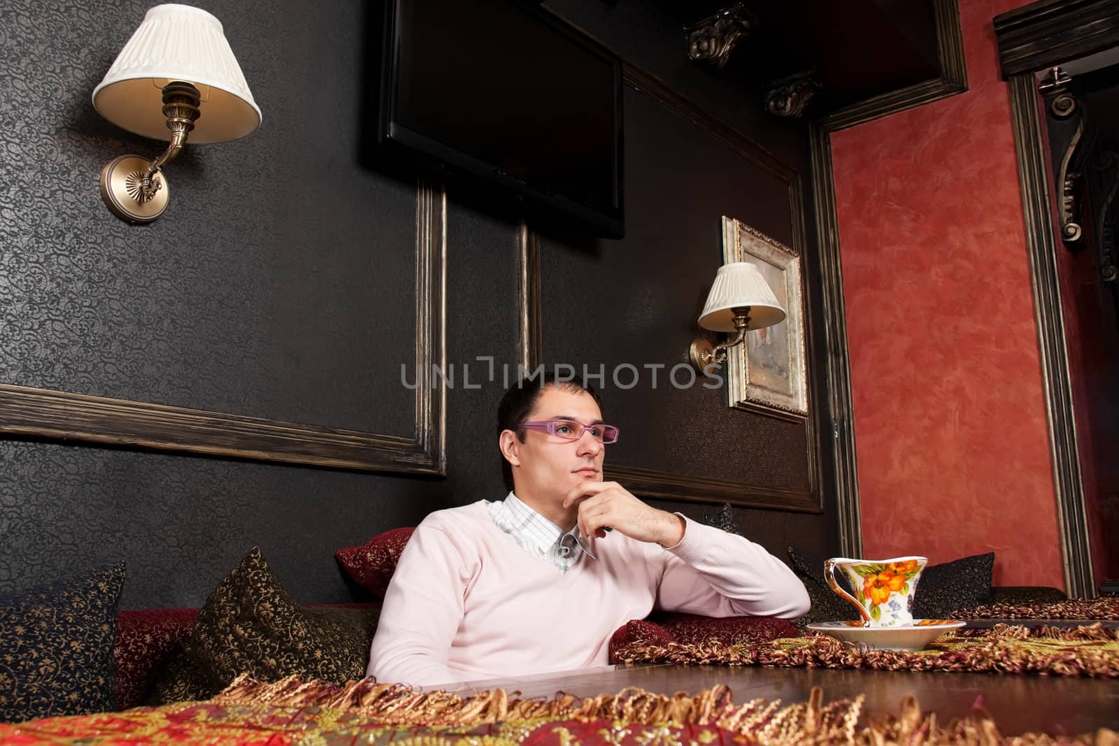 Successful young man sitting in luxury interior