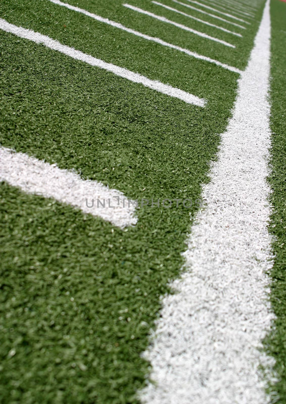 Green football field with large yard markers.