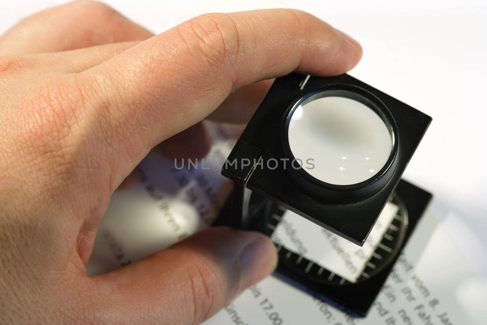 Shallow depth of field image of a printer using a loupe to check text.
