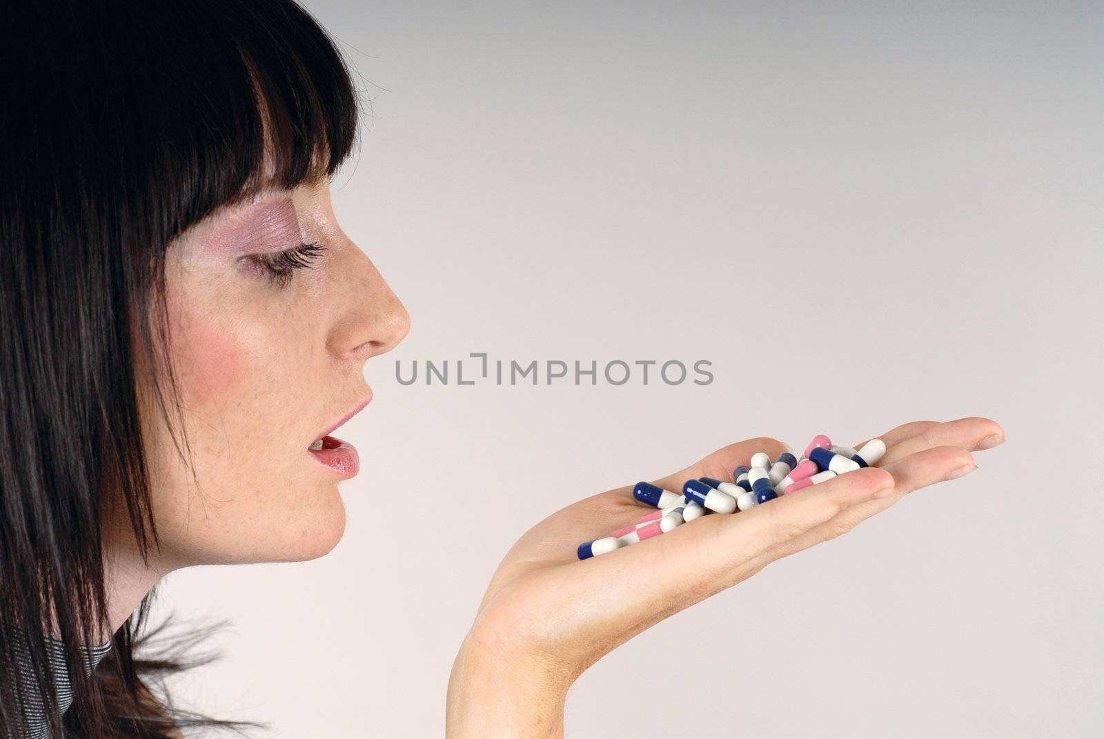 Young woman look at colours pills