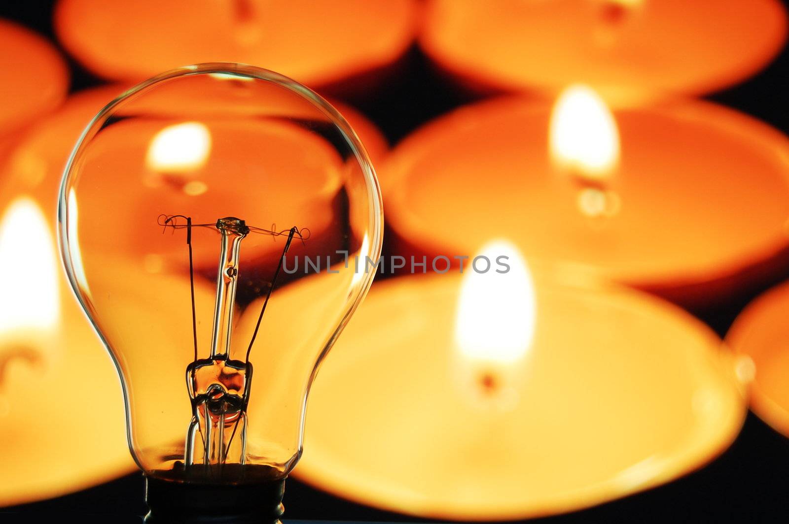 bulb and candle showing concept of saveing anergy