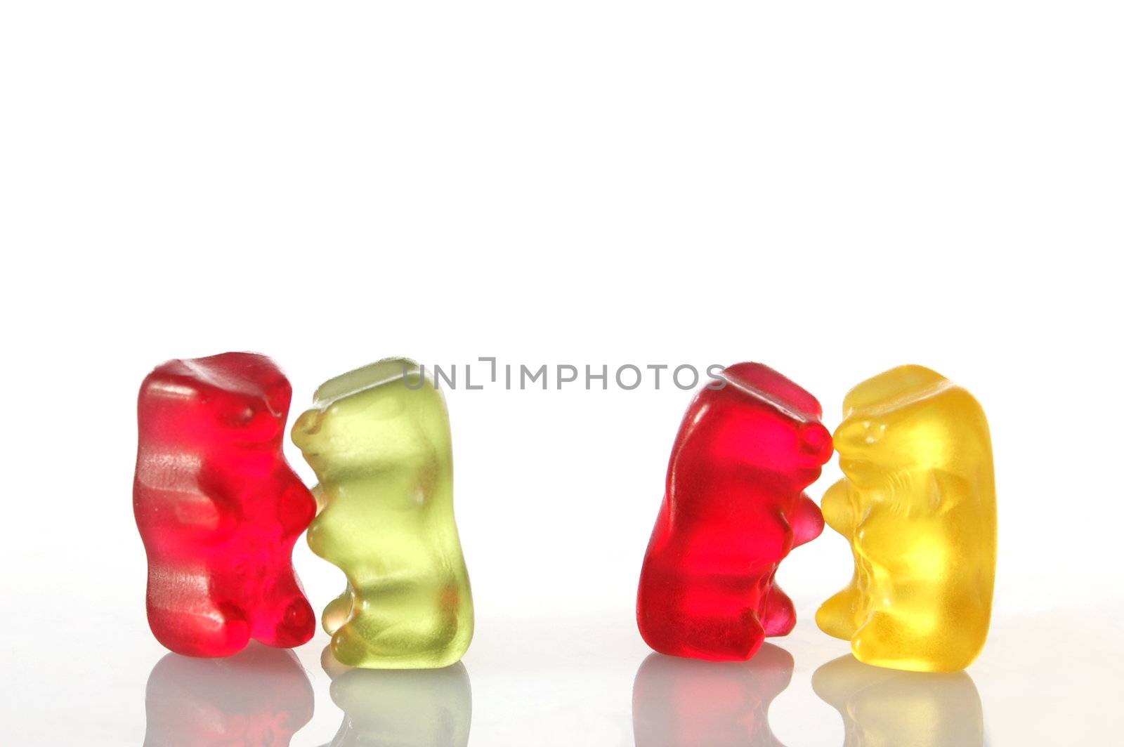 sweet gummy bears dancing on a party on white background