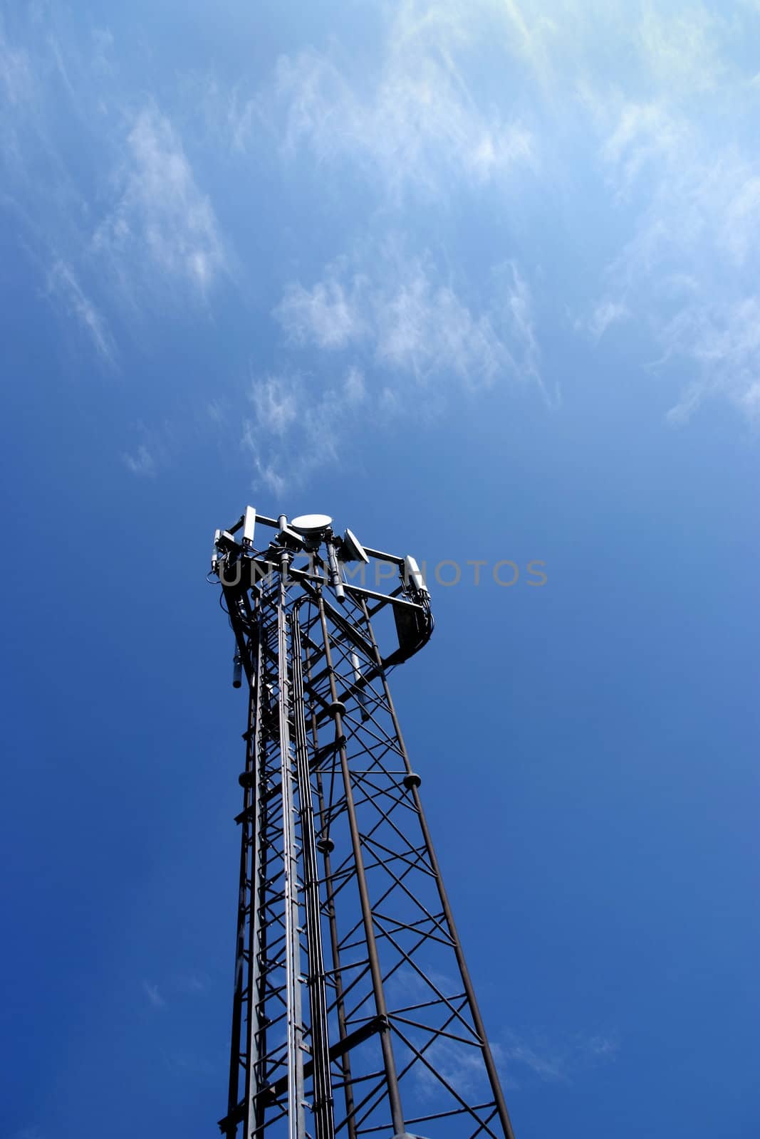 Telecommunication mast with a blue sky background and the sun setting