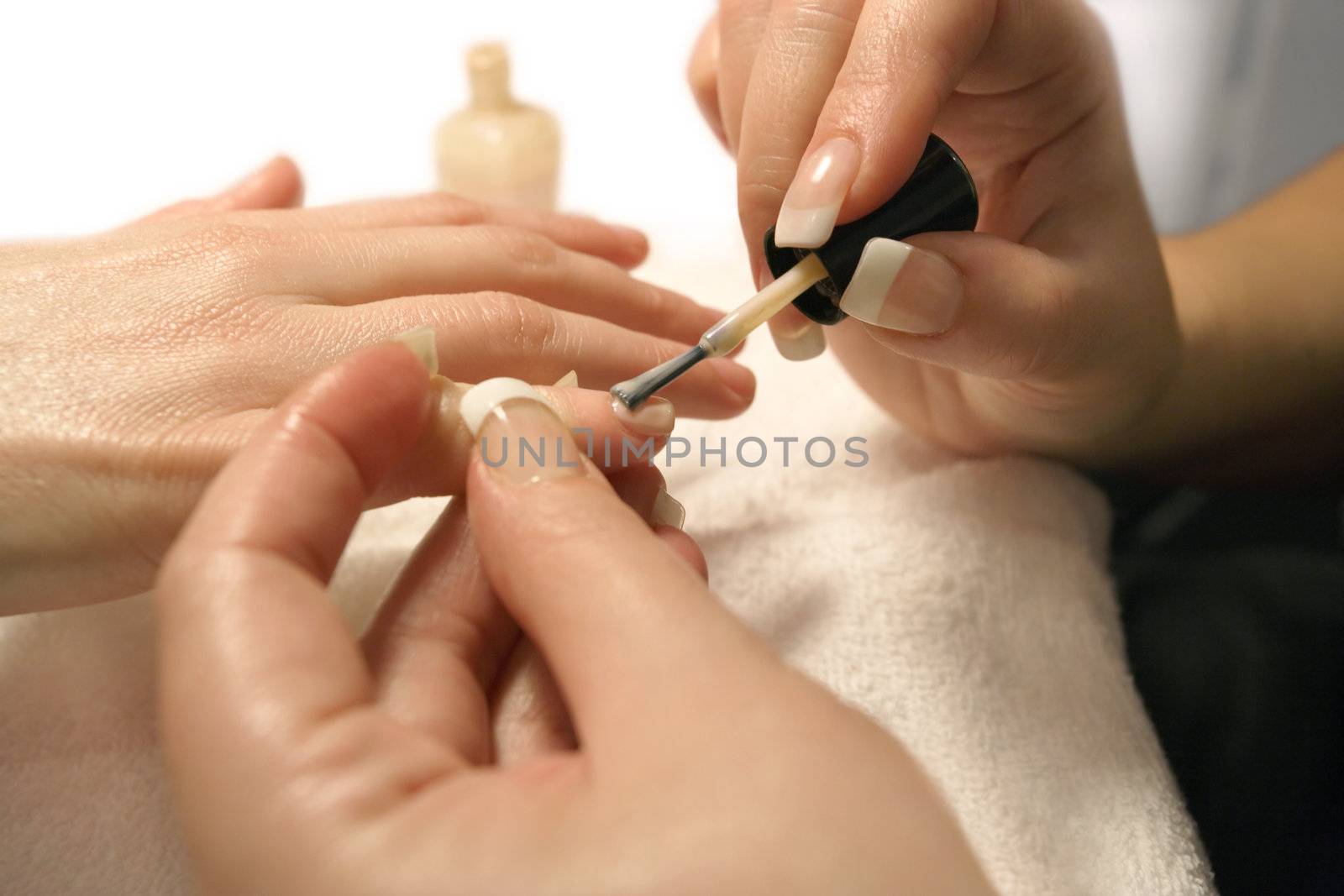 A manicurist applying nail polish during a manicure.

