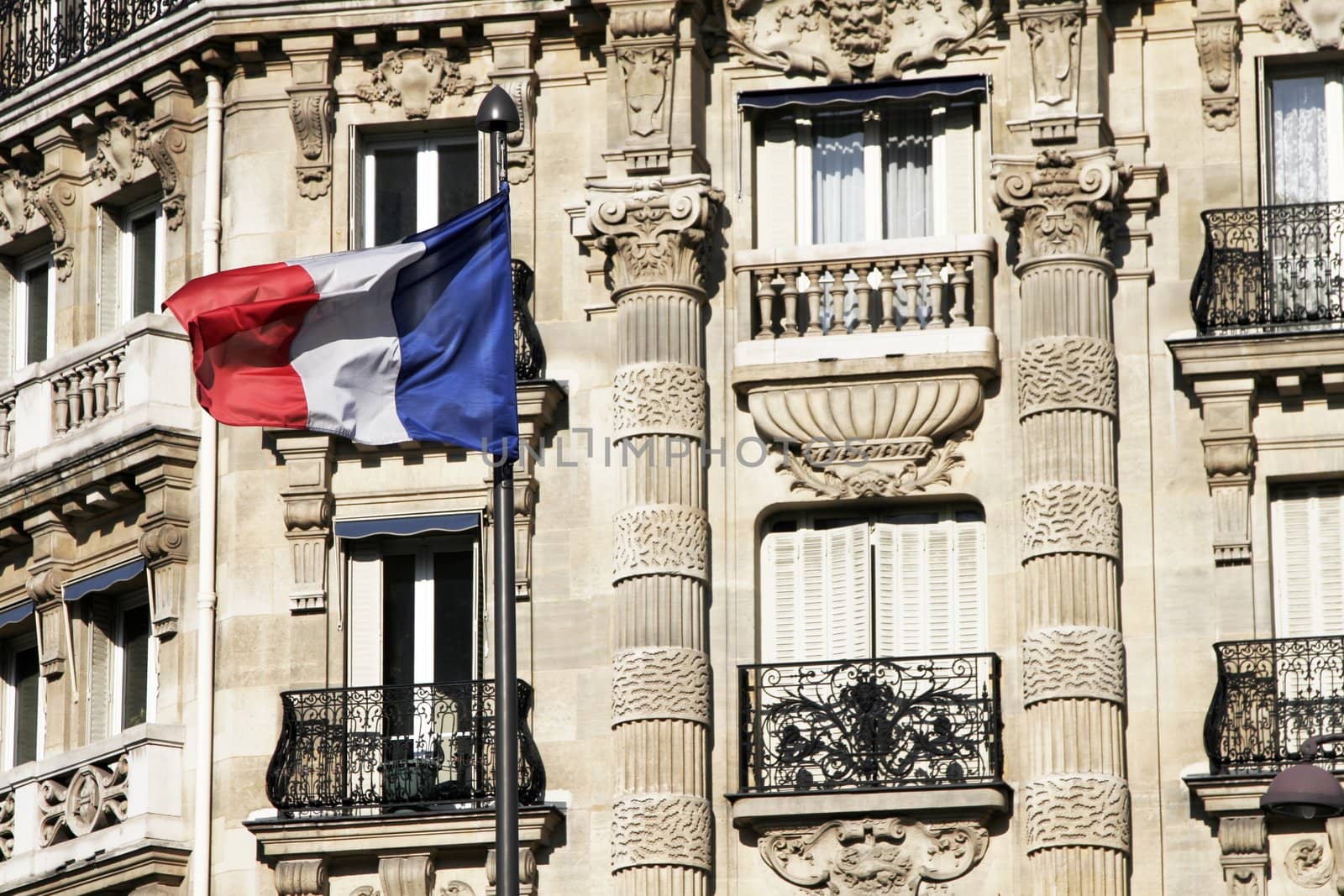 Freanch Flag Blowing In Front Of A Traditional Paris Building